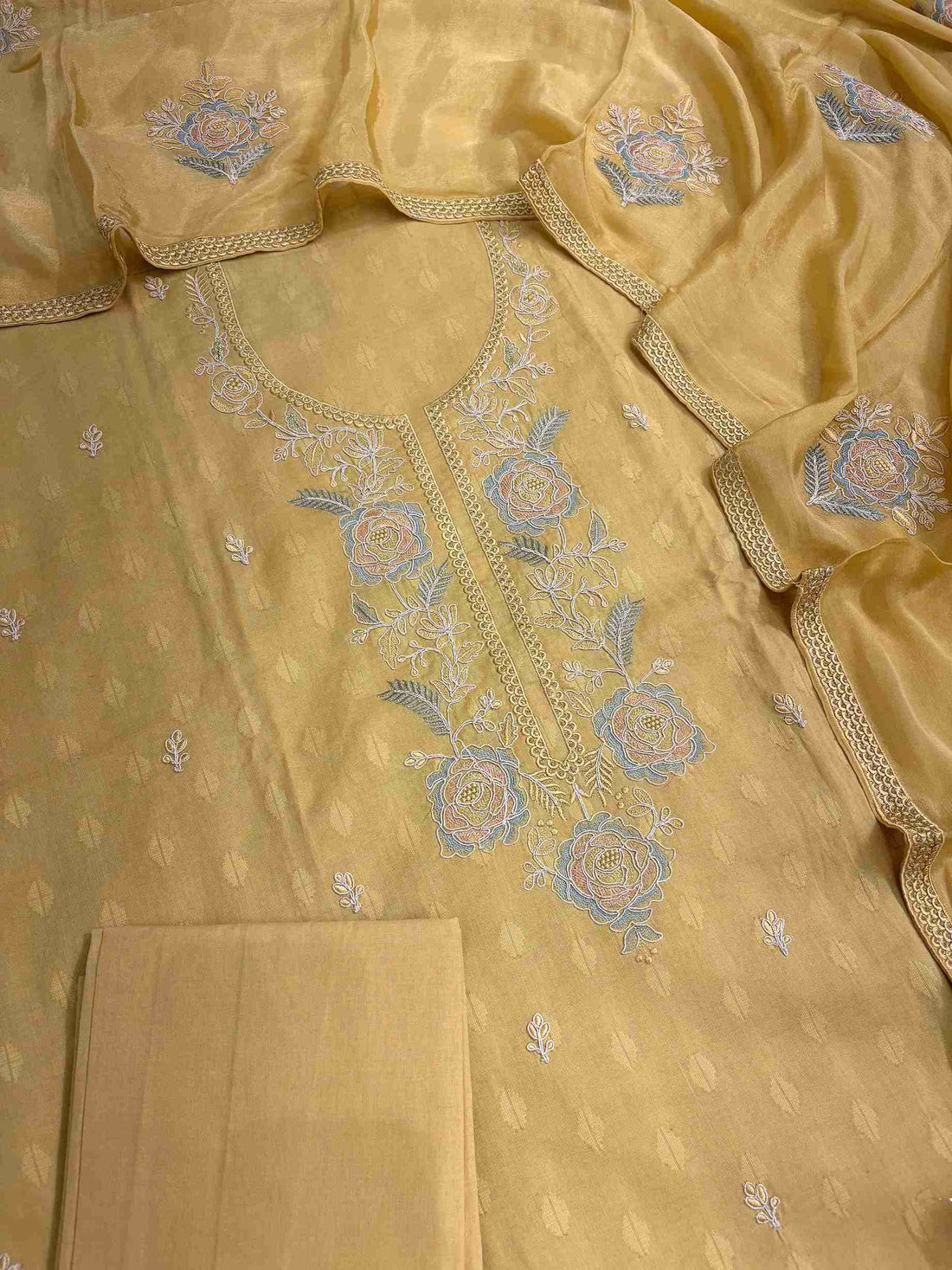 Close-up of floral rose embroidery on mustard yellow cotton suit neckline