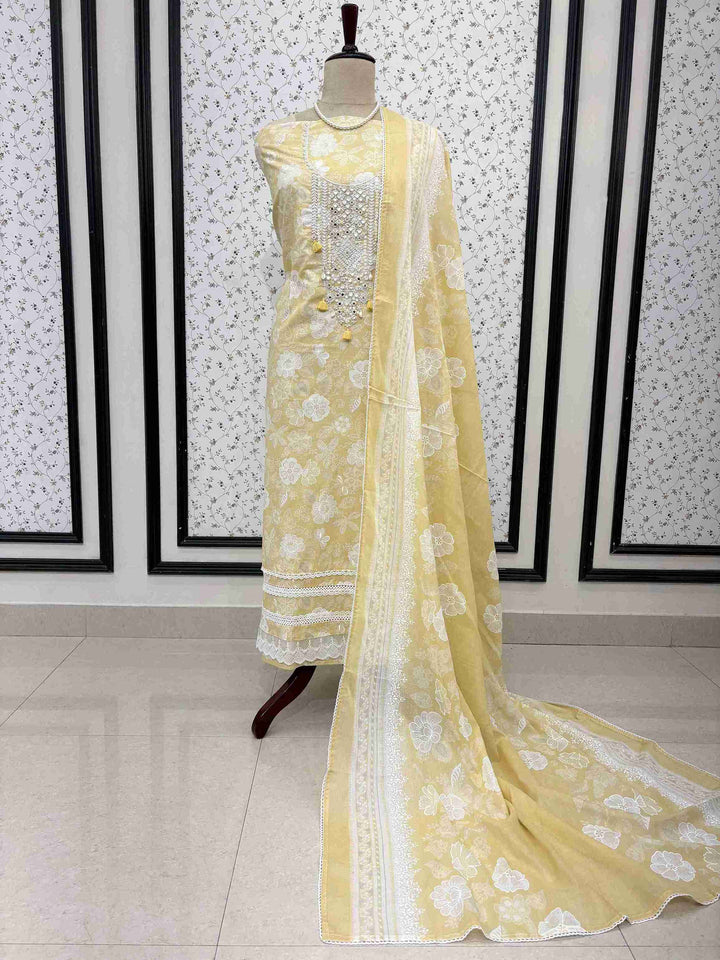 Yellow cotton unstitched suit full front view with floral printed dupatta with lace border draped on mannequin