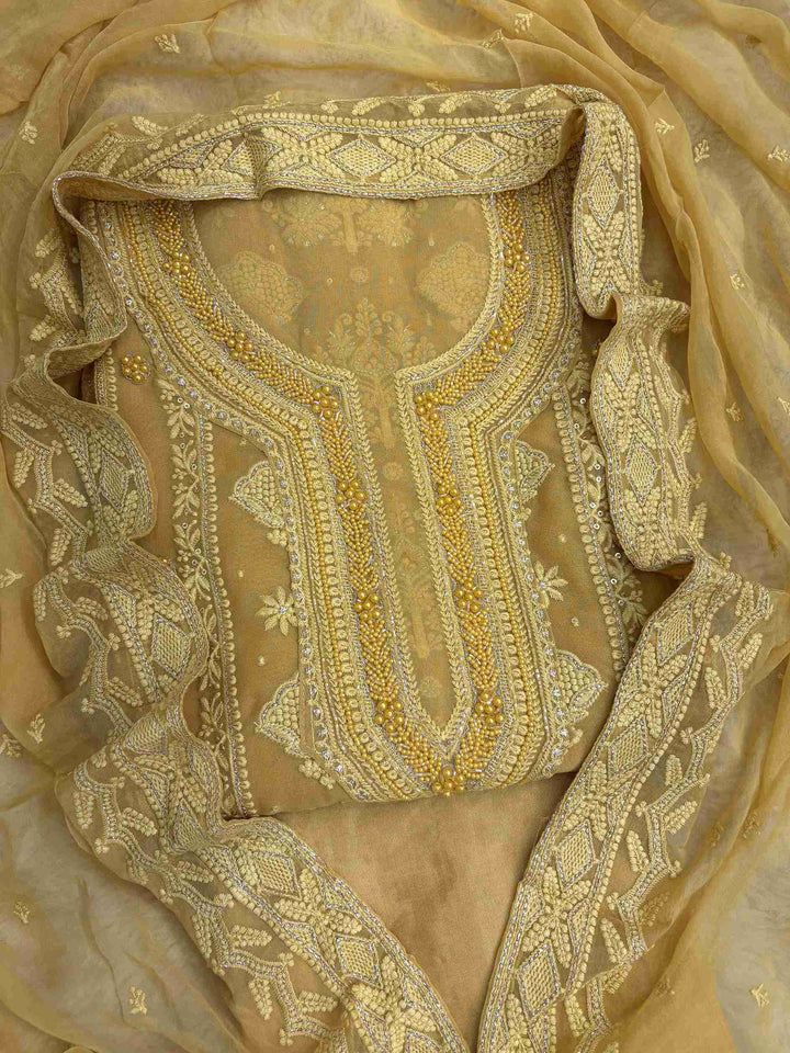 Mustard yellow georgette unstitched suit front view with heavy neckline embroidery and chiffon dupatta