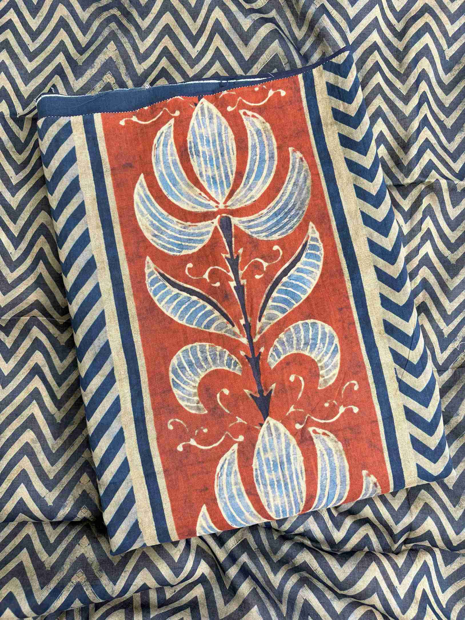 Large rust and blue floral inspired motifs on central front panel of navy blue mul cotton shirt