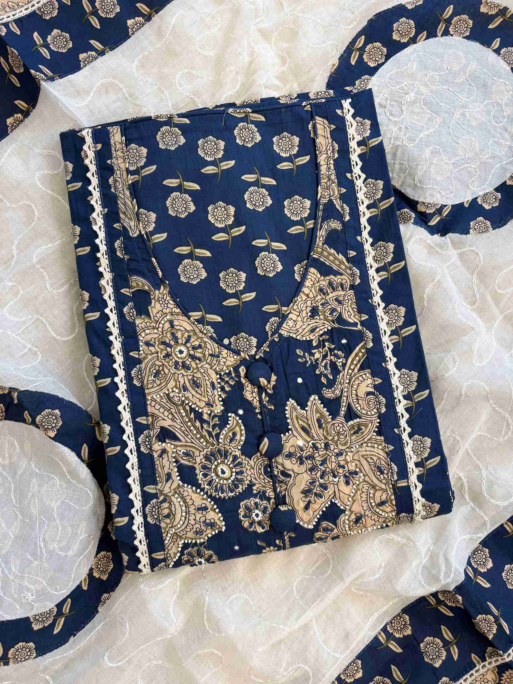 Applique neckline panel with crotia lace border detail on navy blue golden floral print cotton shirt