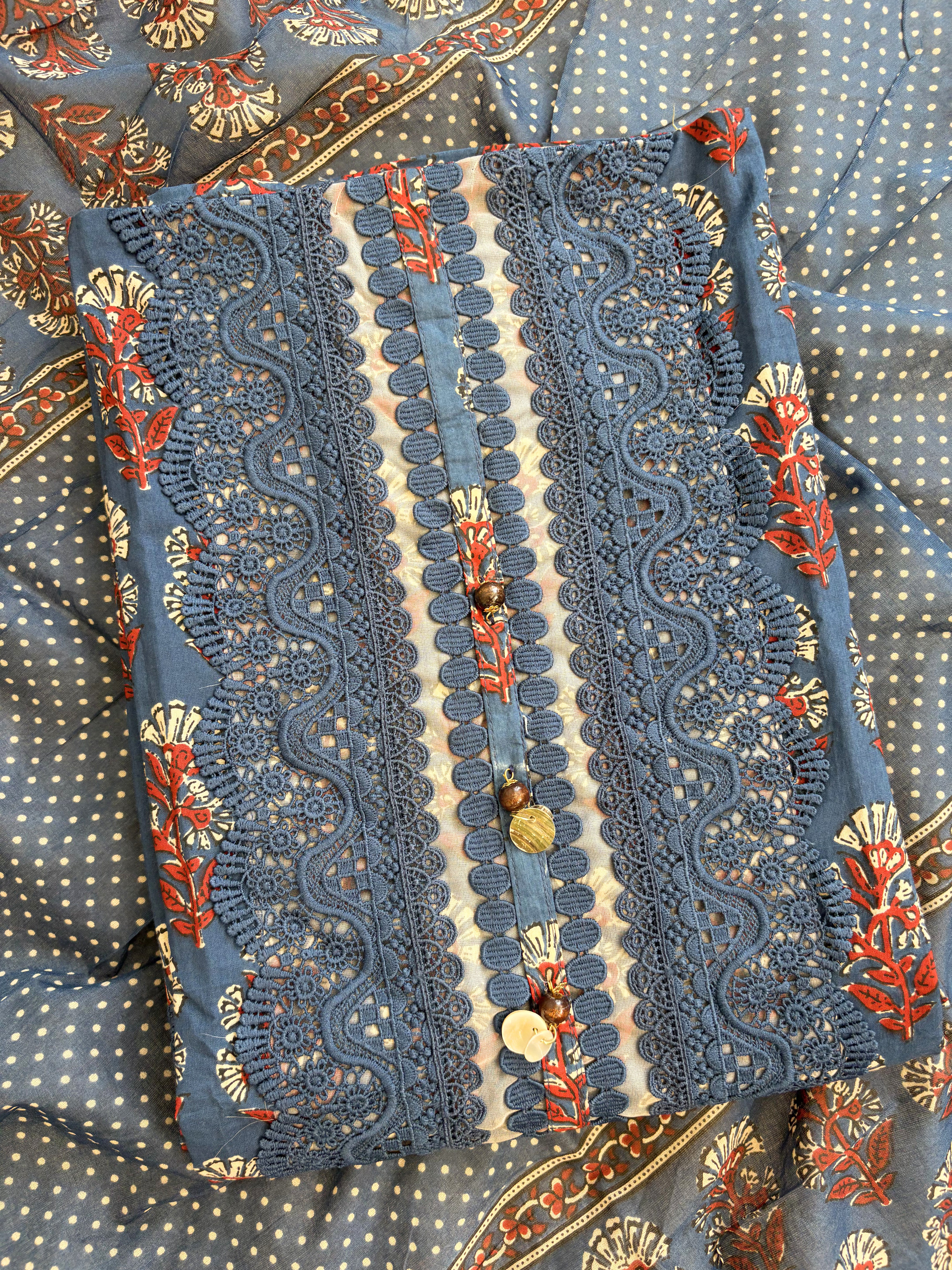 Rectangular neckline panel with schiffili cutwork embroidery and decorative tassels on navy blue cotton shirt