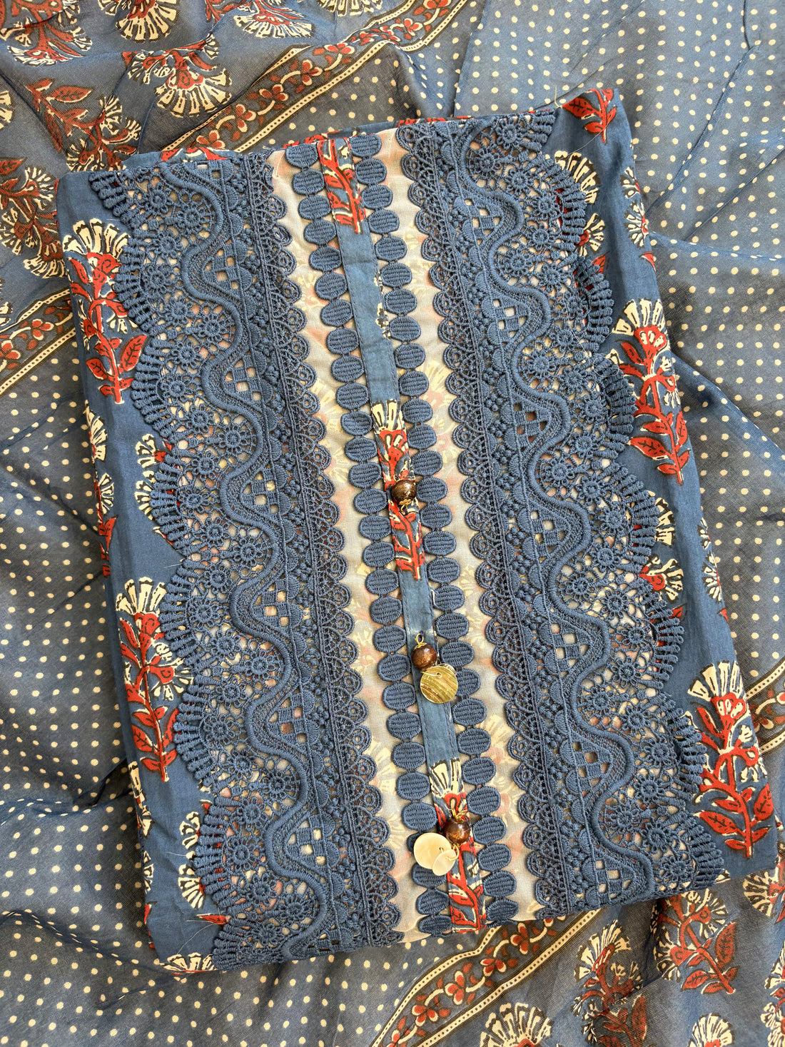 Rectangular neckline panel with schiffili cutwork embroidery and decorative tassels on navy blue cotton shirt