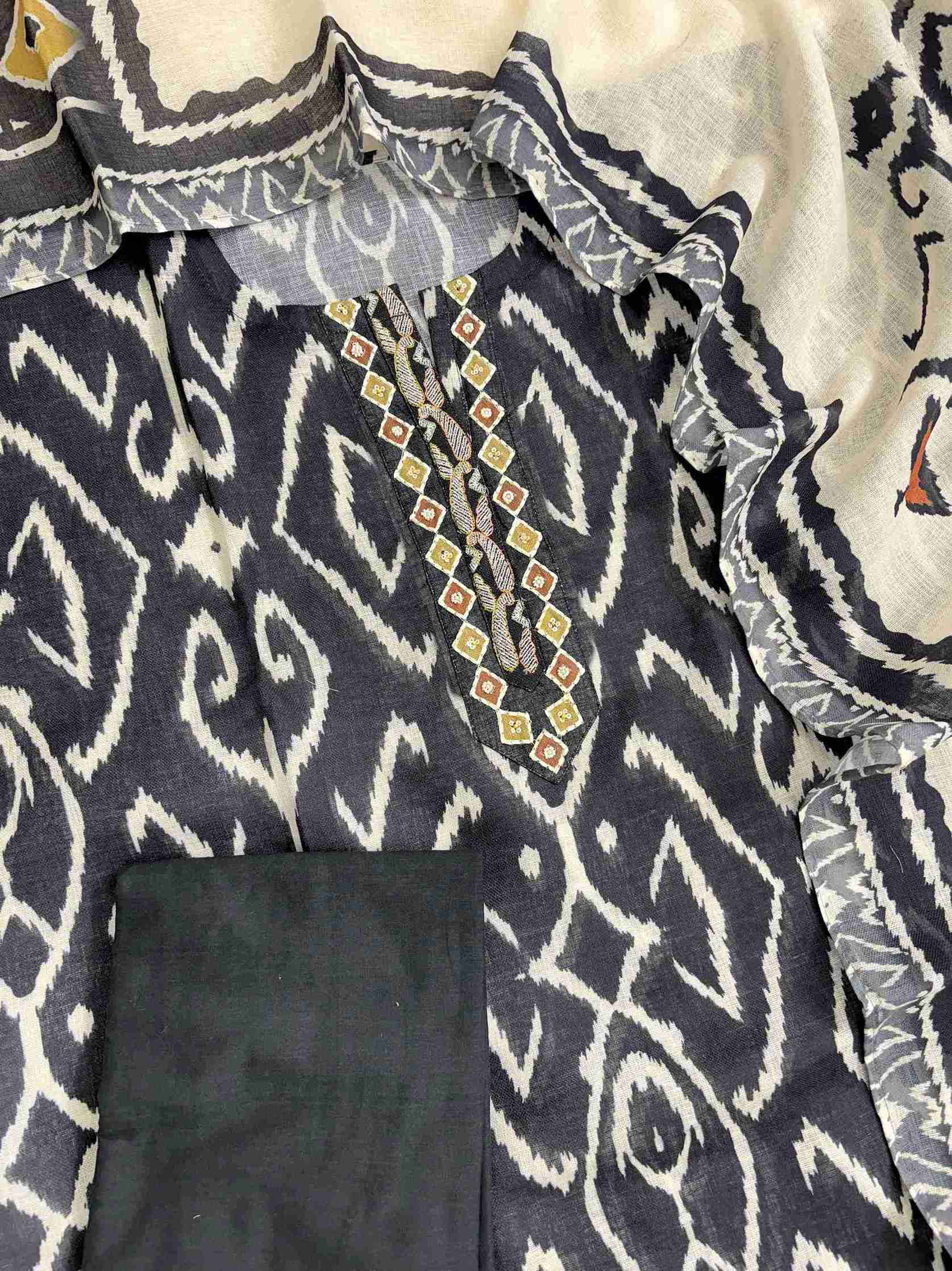 Complete navy blue linen unstitched suit flat lay set with ikat print shirt, off-white ikat dupatta, and matching cotton bottom