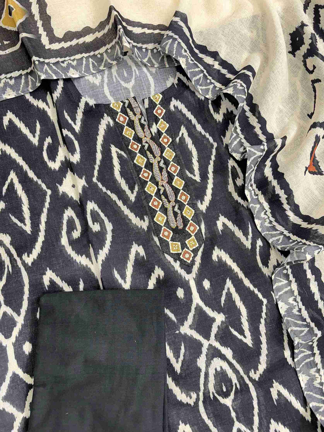 Complete navy blue linen unstitched suit flat lay set with ikat print shirt, off-white ikat dupatta, and matching cotton bottom