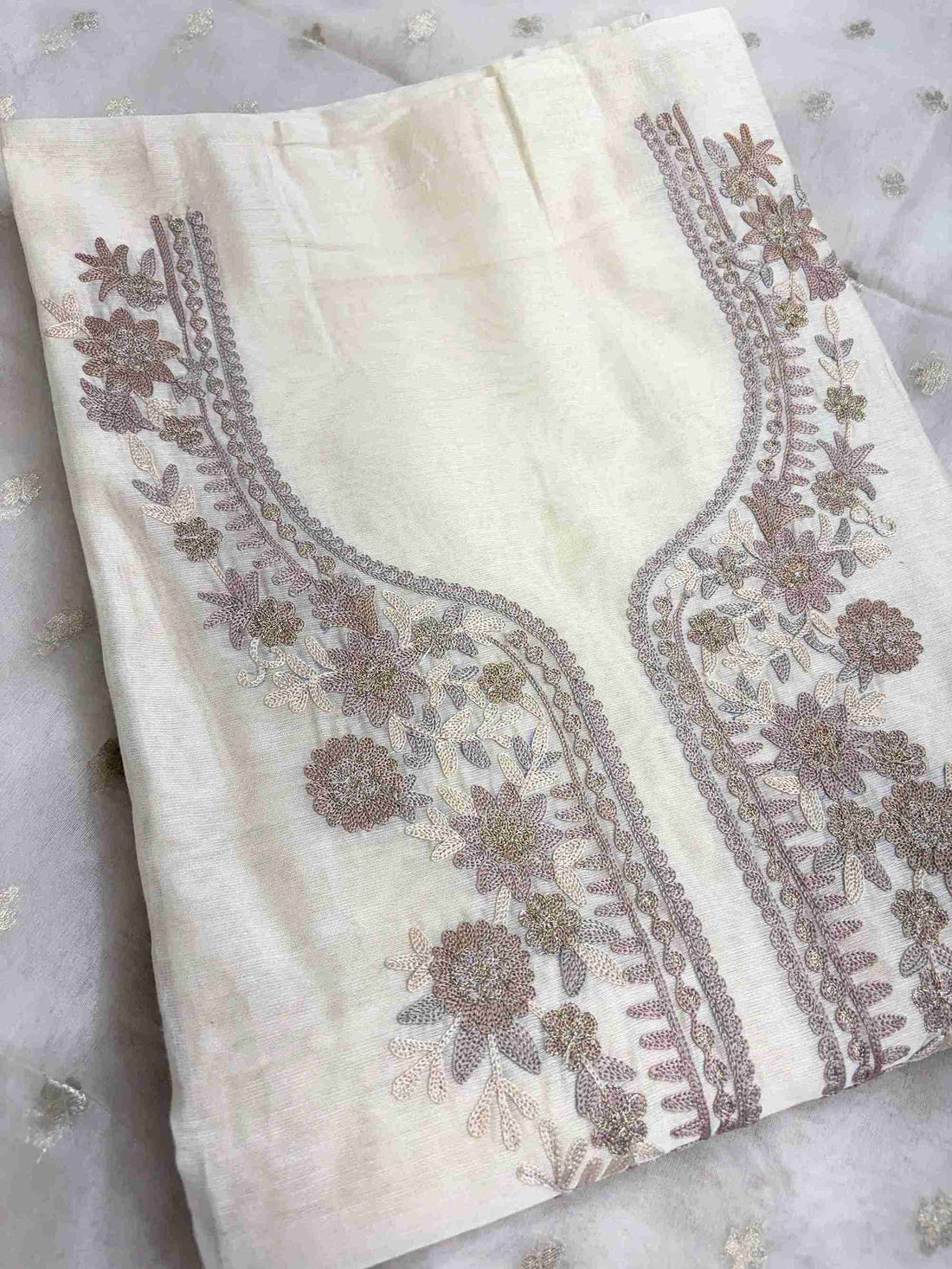 Close-up of aari work floral embroidery on off-white Chanderi suit neckline