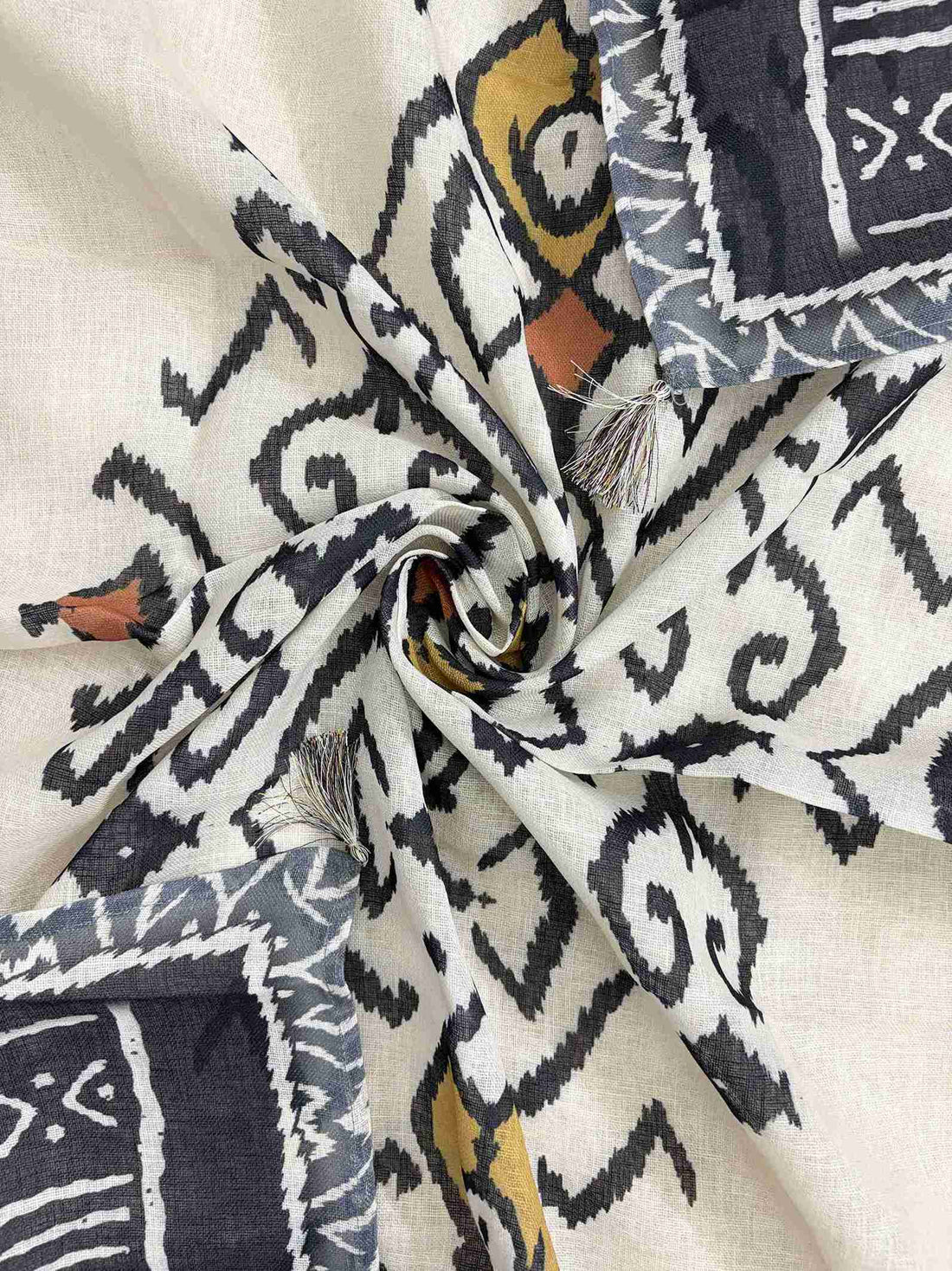 Multicolor ikat geometric print in navy, mustard, terracotta, and grey tones on off-white linen dupatta surface