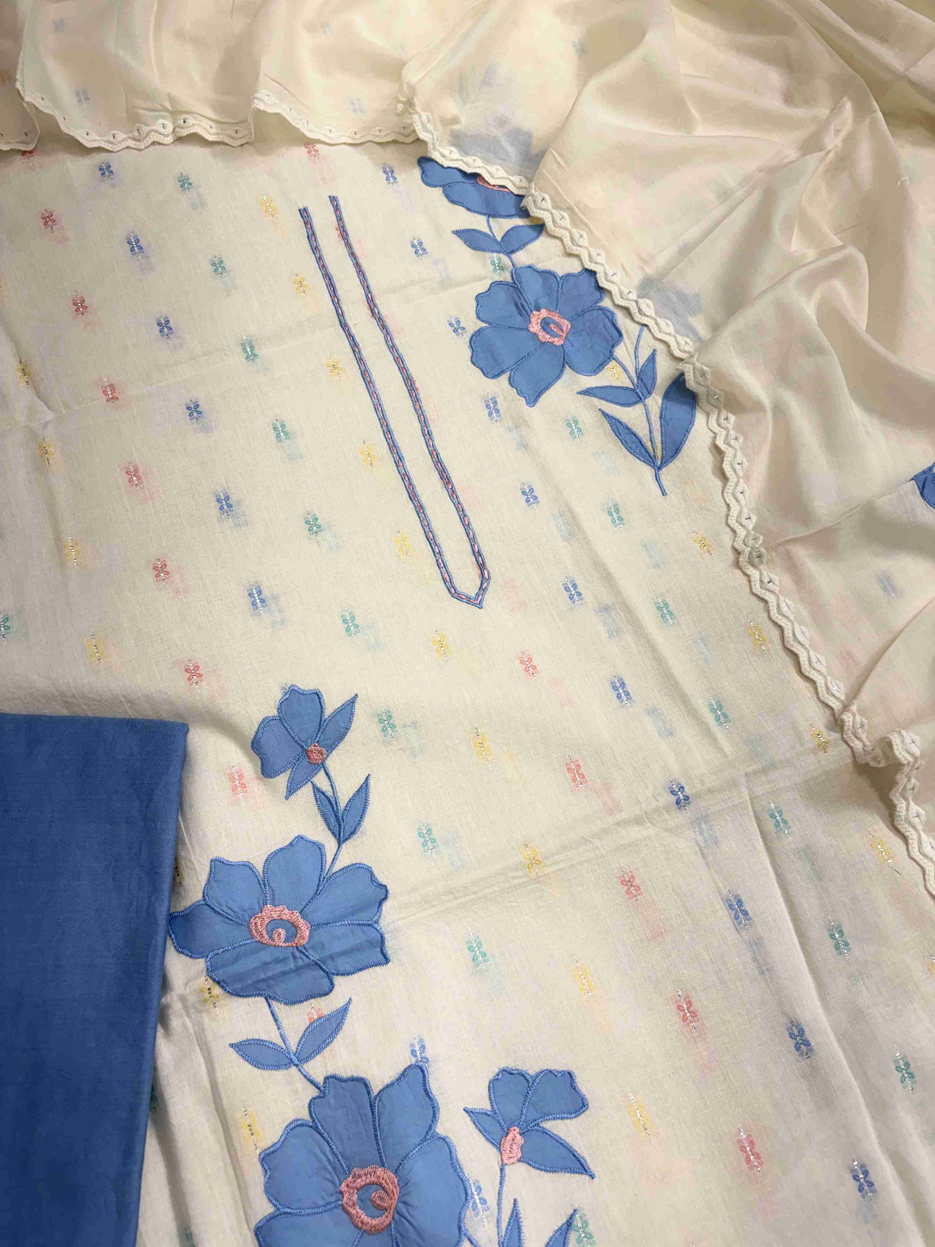 Large blue applique floral patches with golden thread embroidered centers on off-white pure cotton shirt