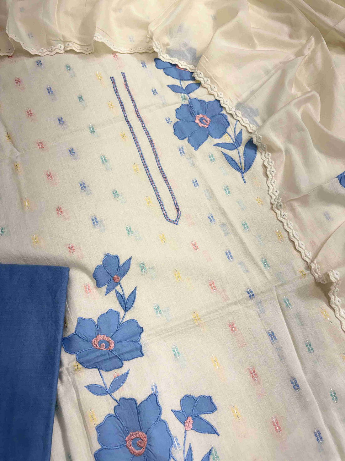 Large blue applique floral patches with golden thread embroidered centers on off-white pure cotton shirt
