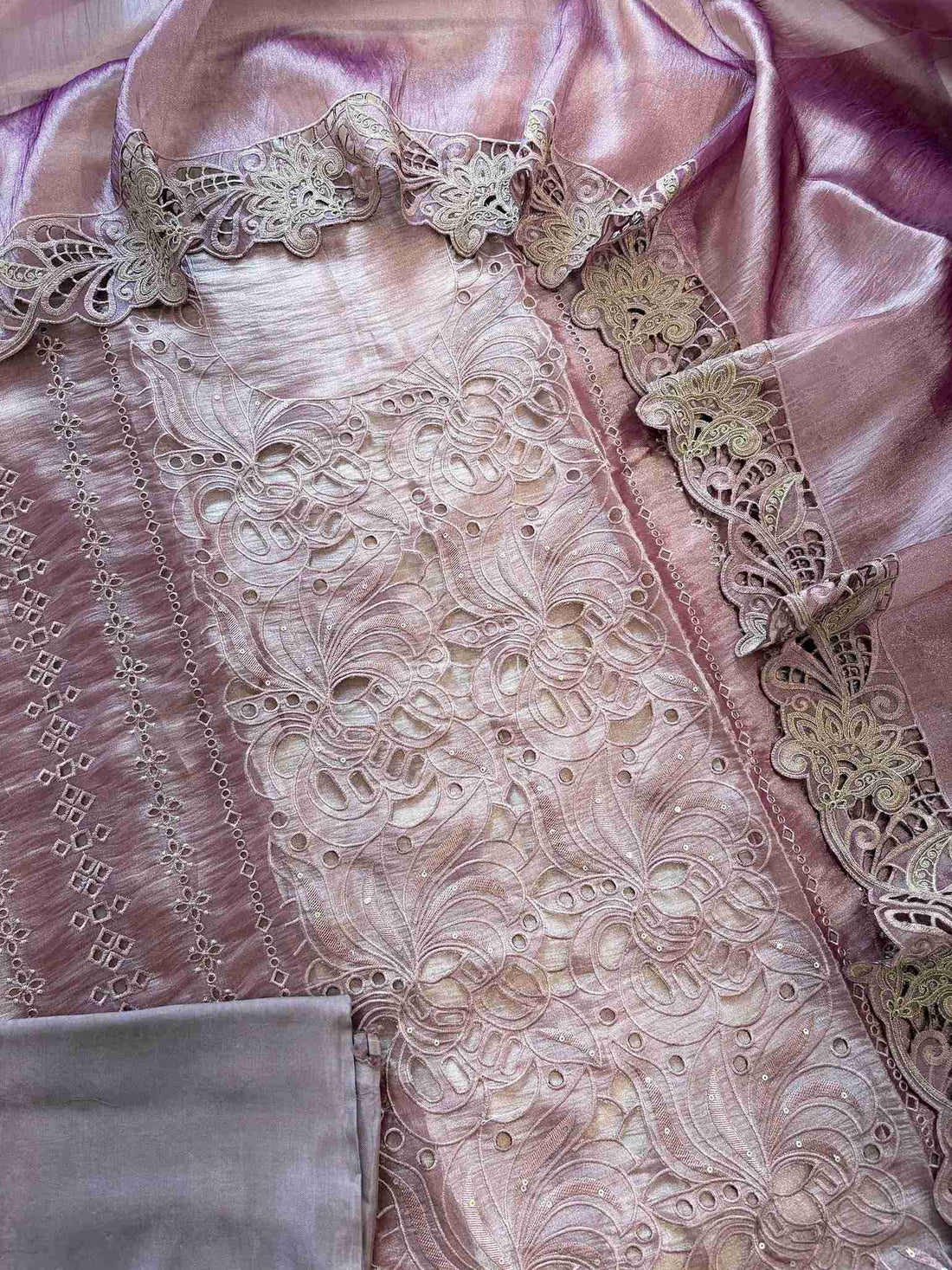 Cutwork detailing along the hemline of onion pink shimmer tissue suit