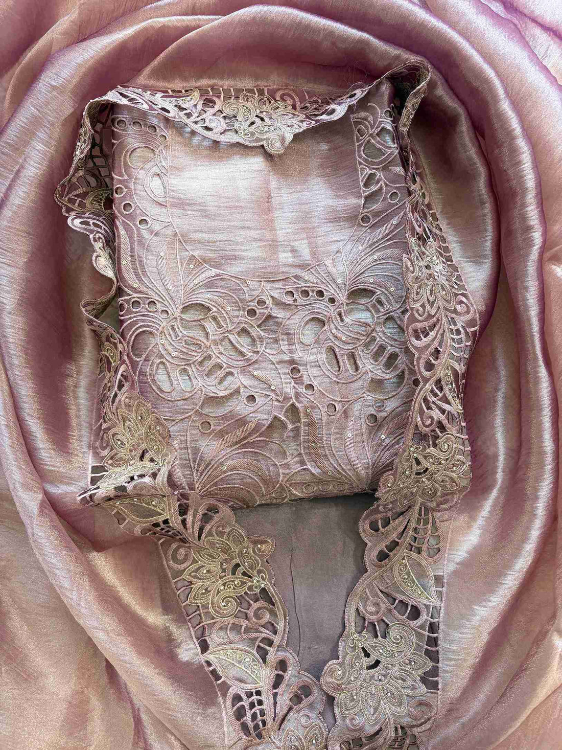 Close-up of cutwork panel at the neckline of onion pink shimmer tissue suit