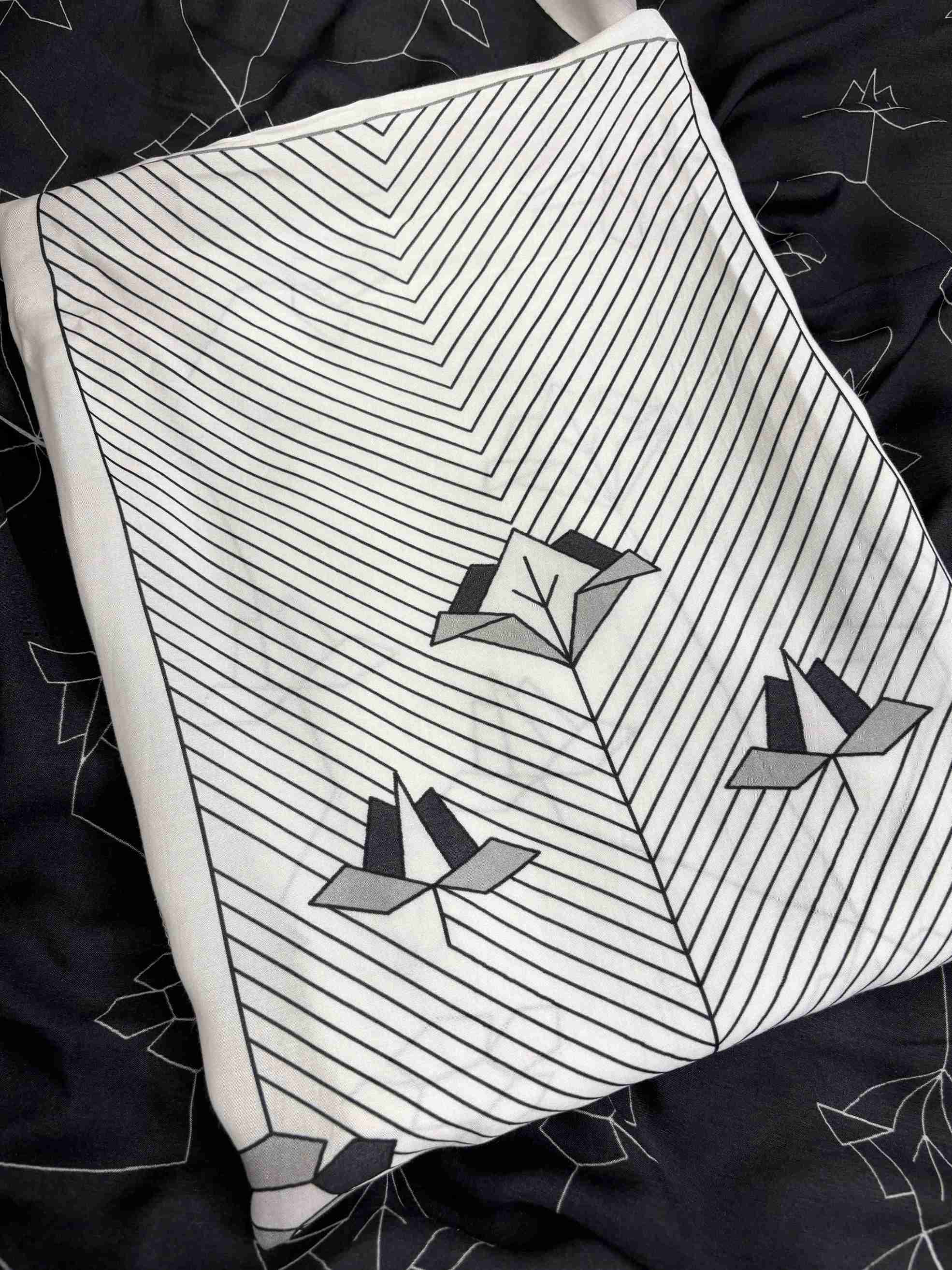 Close up of organza scalloped resham embroidery border on neckline on white and black muslin suit