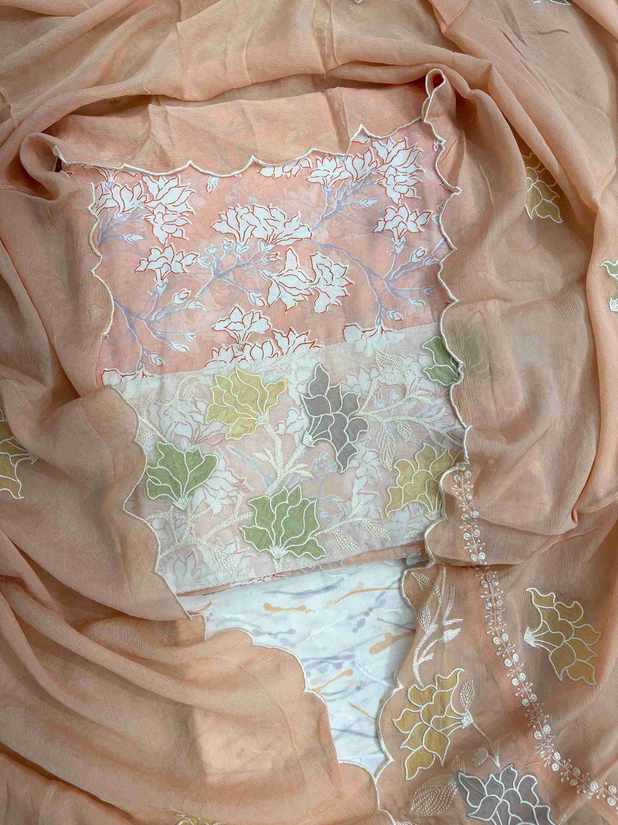 Close-up of all-over white floral print with blooming clusters and branches on peach cotton shirt body