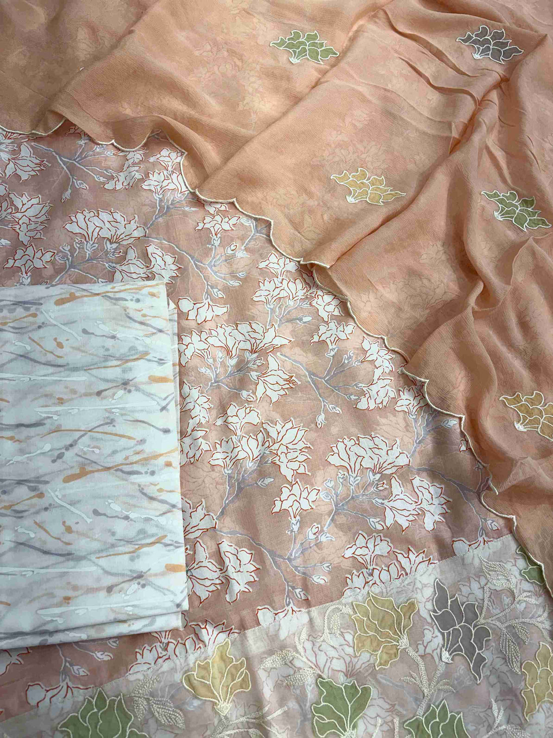 Complete peach cotton unstitched suit flat lay set with floral printed shirt, chinnon dupatta, and cotton bottom