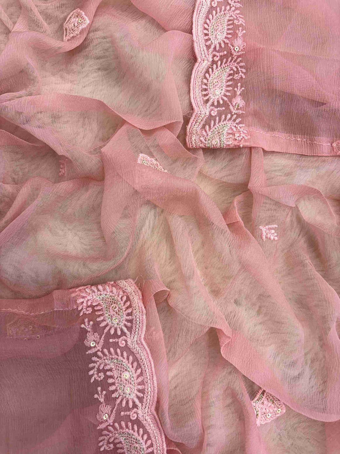 Chikankari border with scalloped finishing along peach pink chiffon dupatta edge
