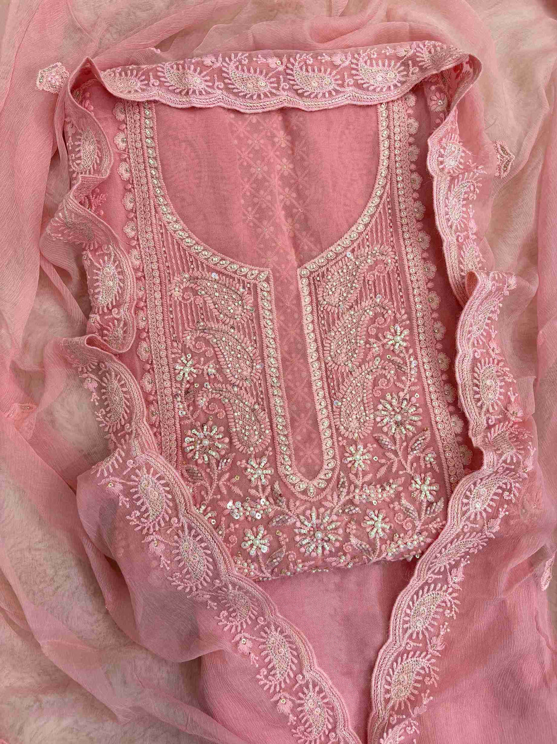 Close-up of chikankari neckline panel with moti, bead, and sequin embellishment on peach pink georgette shirt