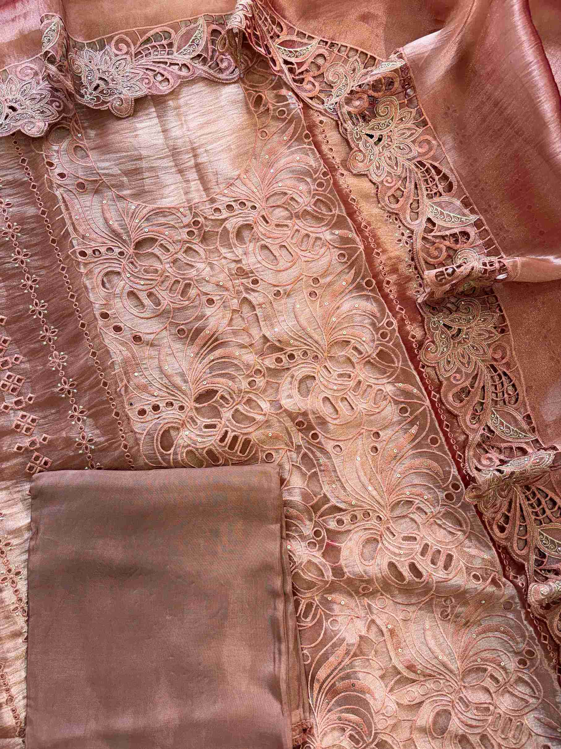 Close-up of cutwork panel at the neckline of peach shimmer tissue suit