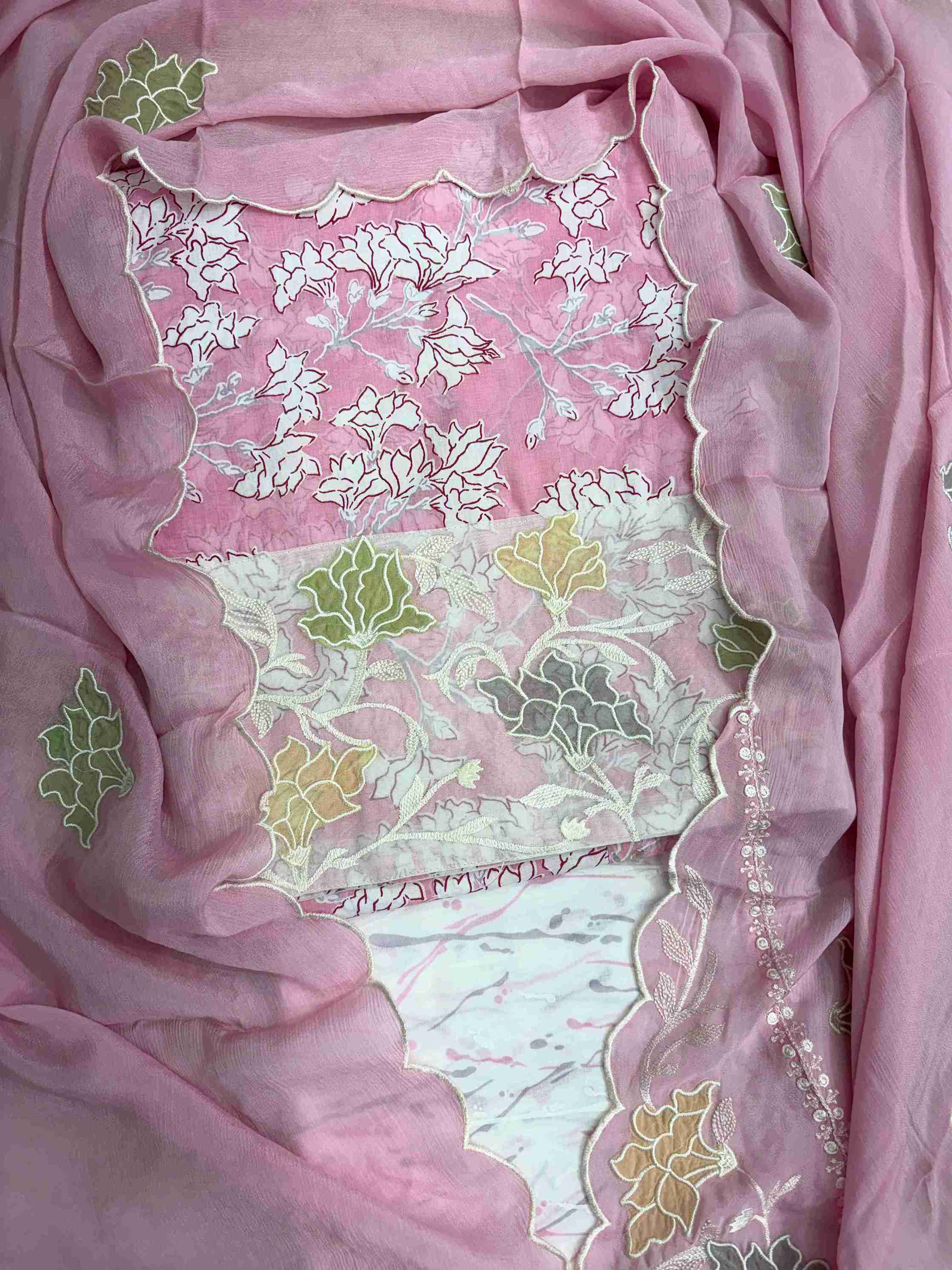 Close-up of all-over white floral print with blooming clusters and branches on pink cotton shirt body