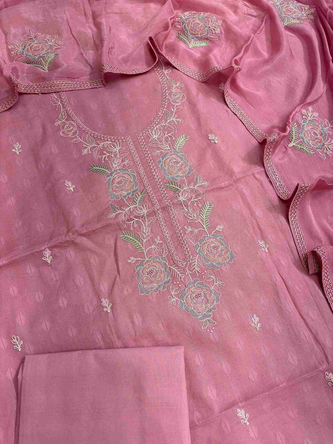 Close-up of floral rose embroidery on pink cotton suit neckline