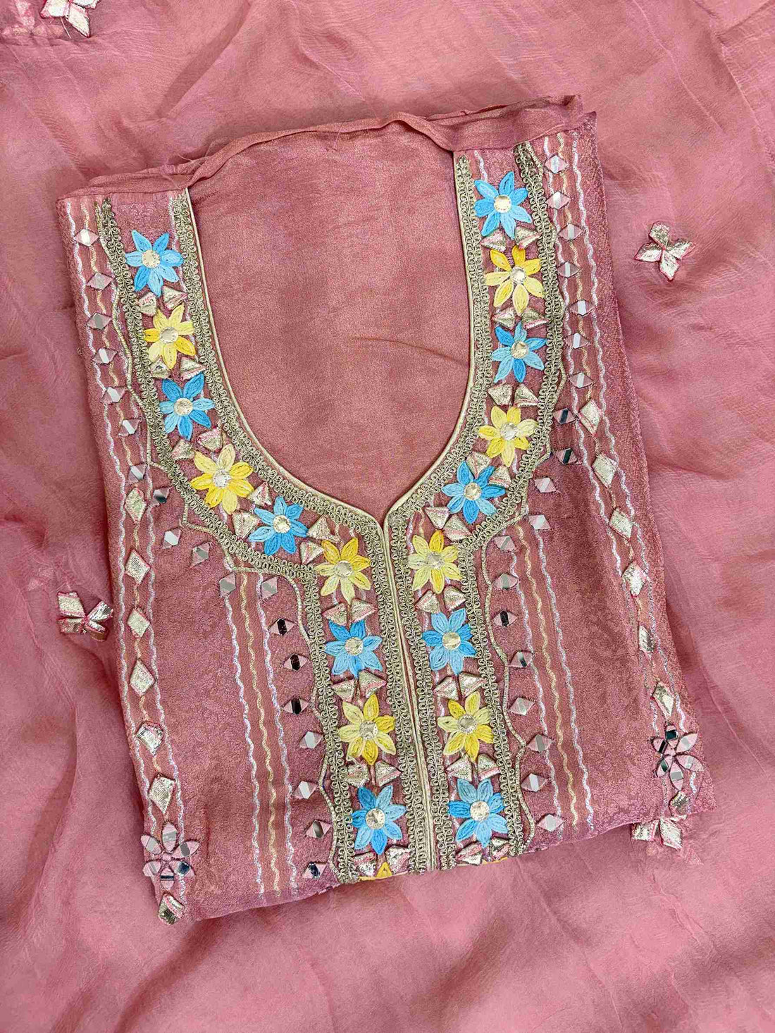 Multicolor thread floral motifs with mirror work and gota highlighting at neckline of pink shimmer tissue shirt
