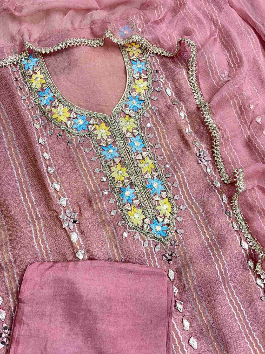 Complete pink shimmer tissue unstitched suit flat lay set with shirt, chiffon dupatta, and opada silk bottom