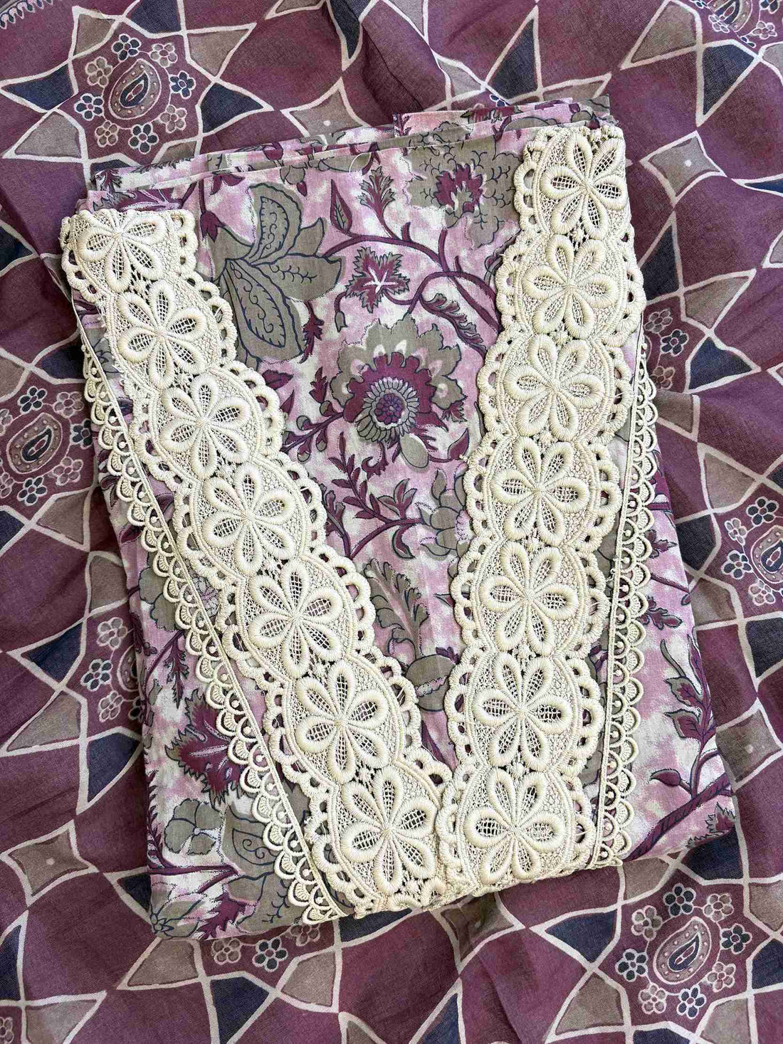 V-shaped neckline with broad crotia lace highlighting and decorative bead and coin tassels on plum cotton shirt