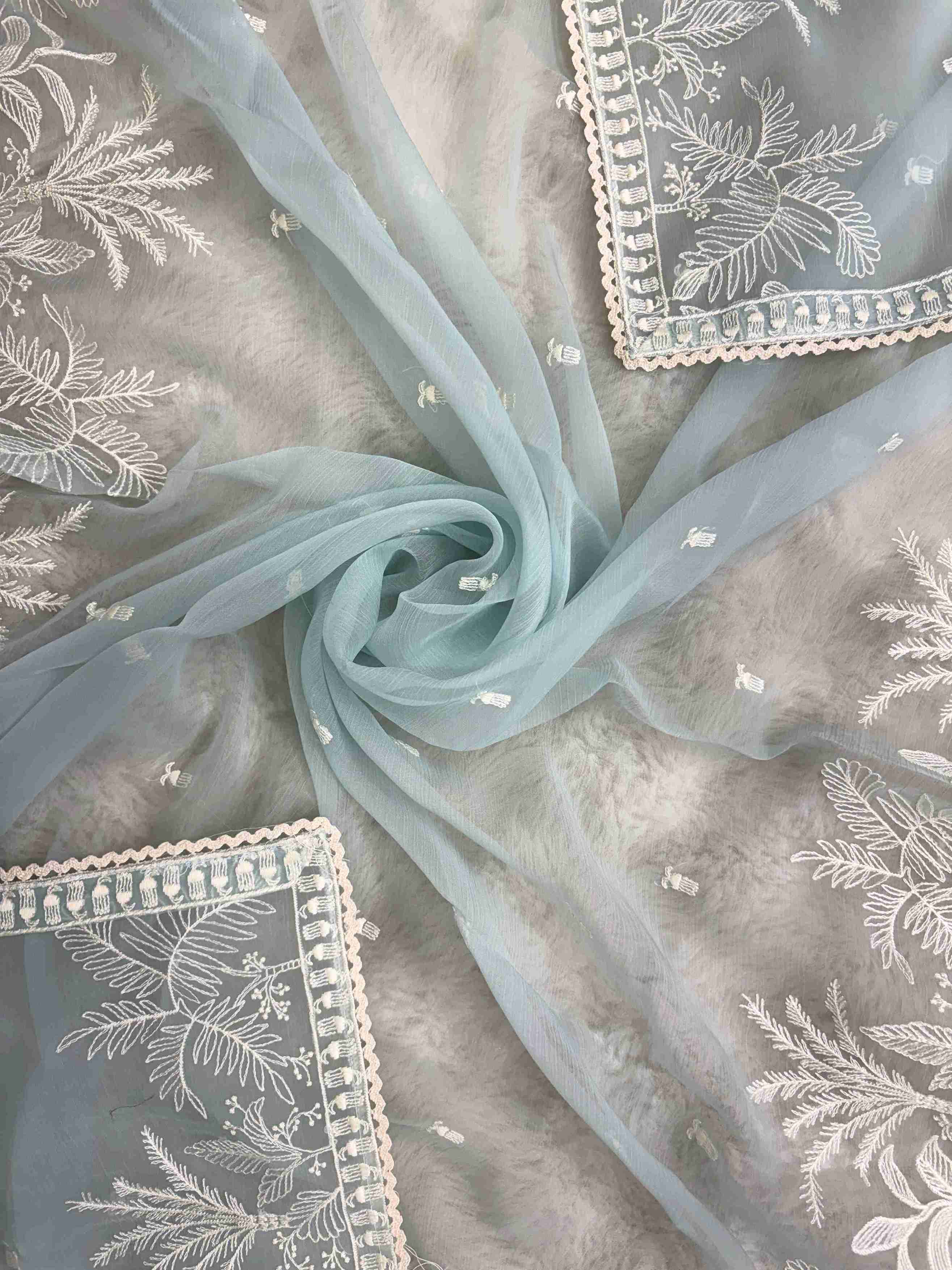 Powder blue embroidered suit showcasing scattered resham thread booties
