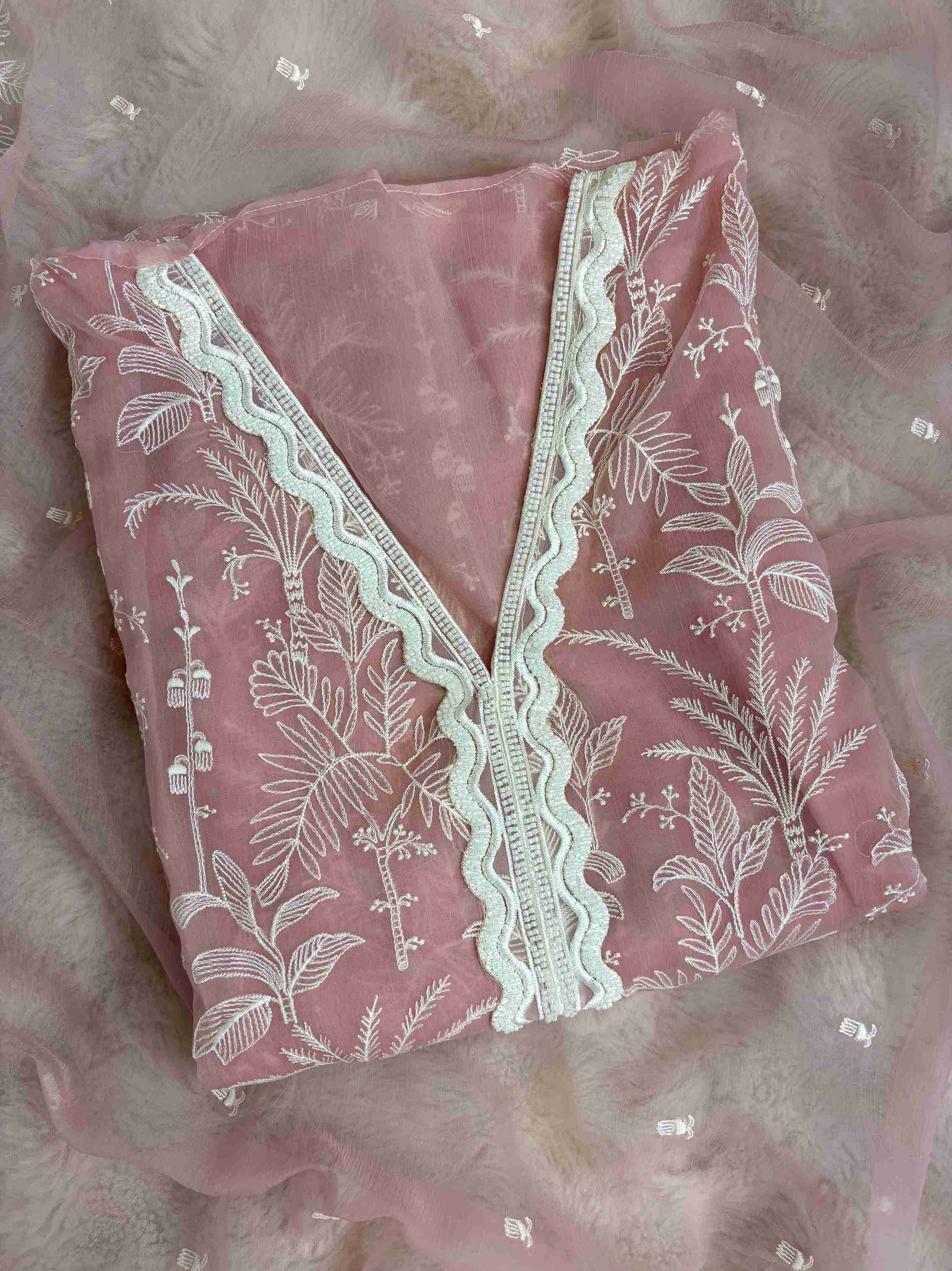 Close-up of V neckline with white cutwork lace and resham embroidery on Powder pink suit