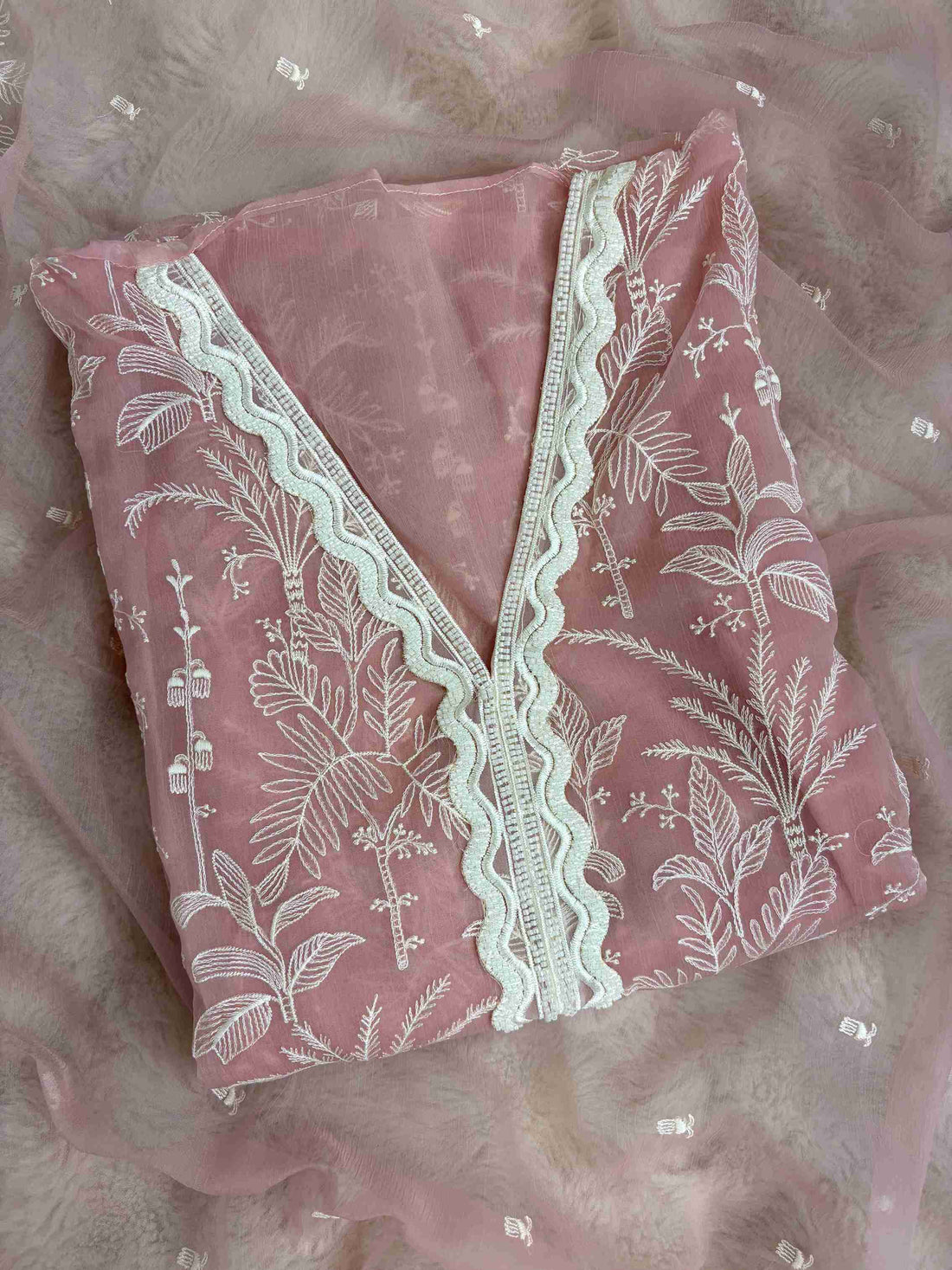 Close-up of V neckline with white cutwork lace and resham embroidery on Powder pink suit
