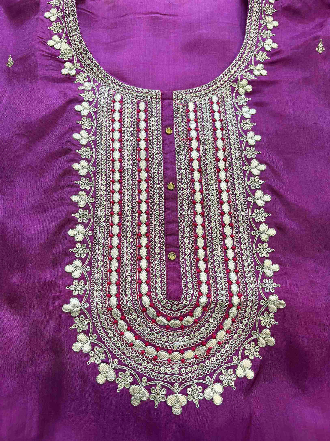 Close-up of embroidered neckline on purple Russian silk kurta fabric