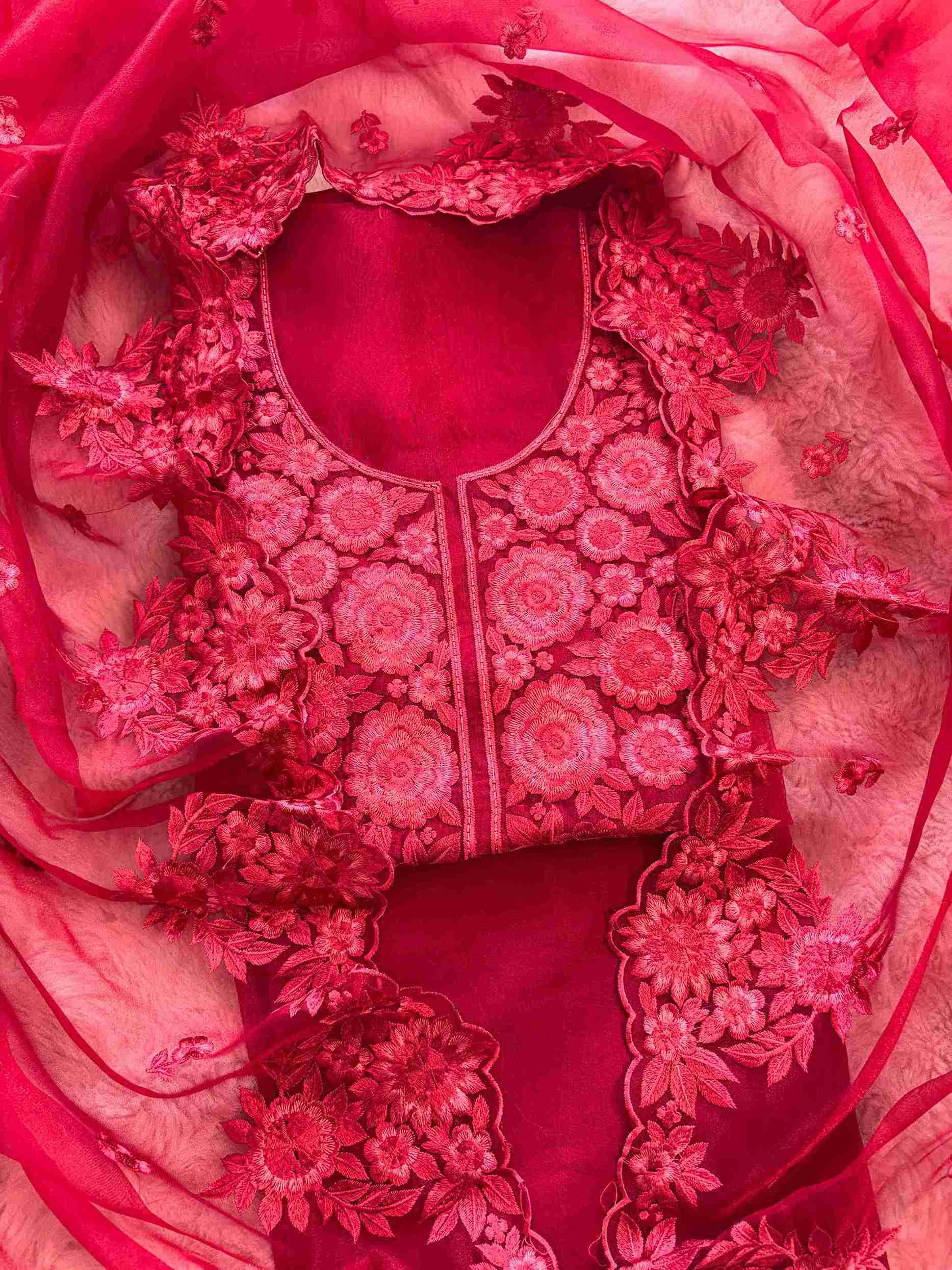 Close-up of monotone thread embroidery on the neckline panel of red glass organza suit