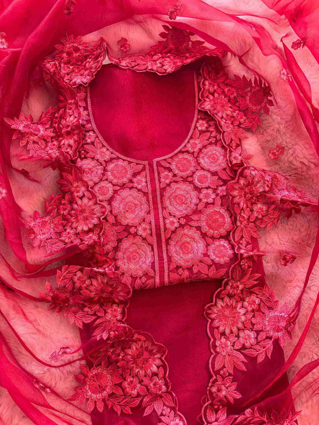 Close-up of monotone thread embroidery on the neckline panel of red glass organza suit