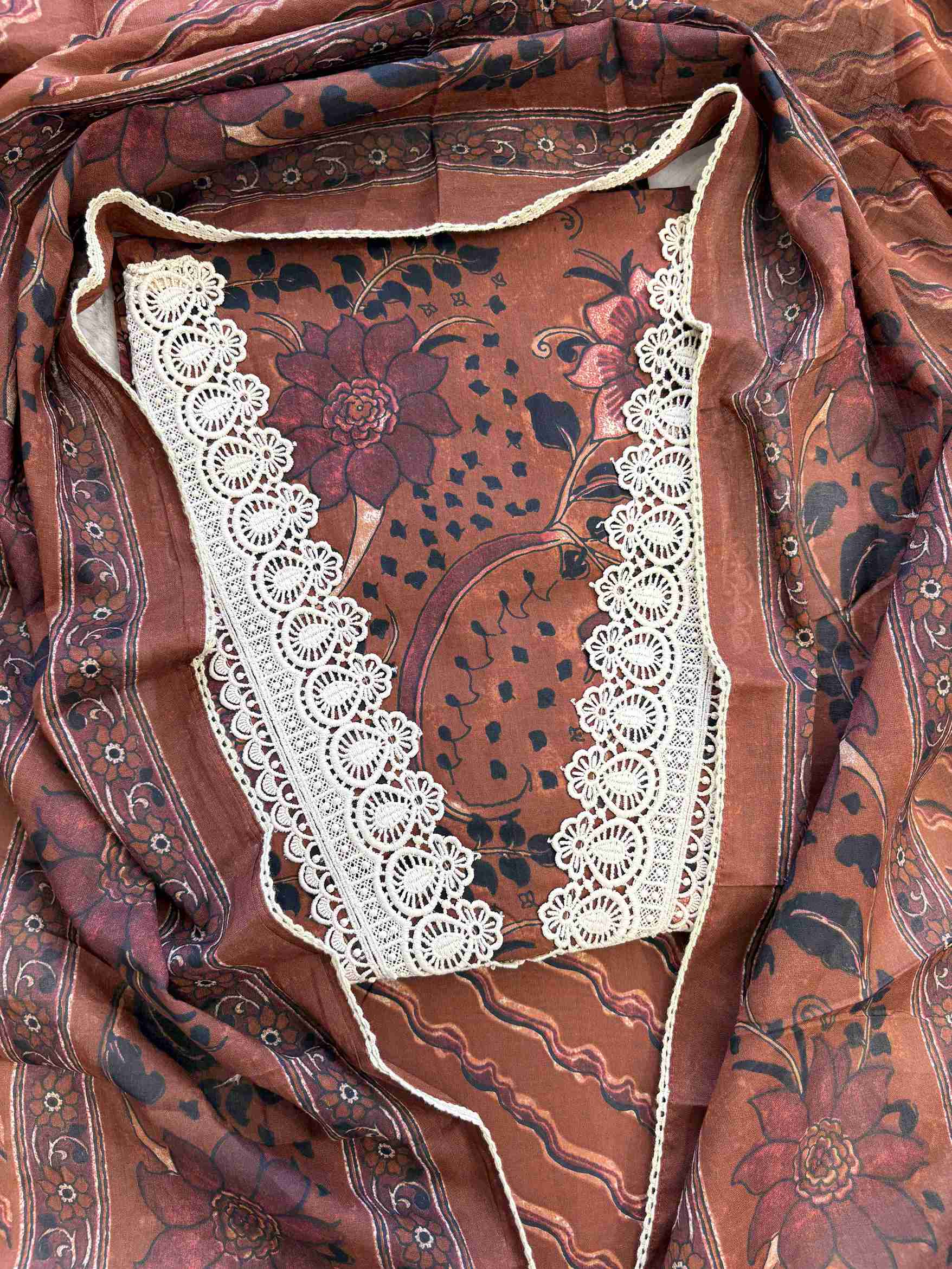 Close-up of all-over digital floral print with paisleys and botanical motifs on rust brown cotton shirt body
