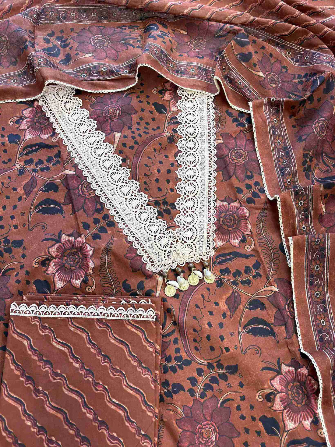 Complete rust brown cotton unstitched suit flat lay set with floral printed shirt, dupatta, and wave stripe printed bottom