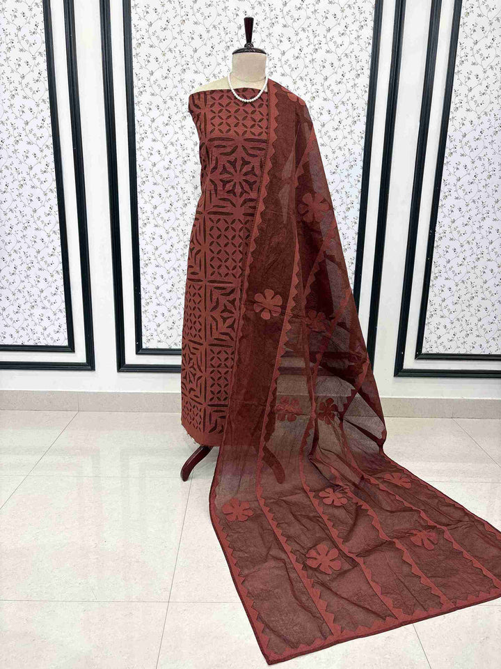 Rust pure cotton unstitched suit displayed on mannequin with applique jaali work and matching dupatta