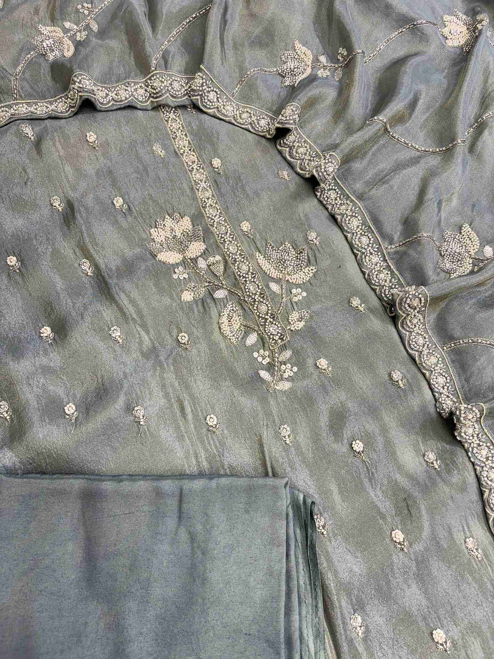 Complete sage grey-green soft tissue unstitched suit flat lay set with shirt, dupatta, and shantoon bottom