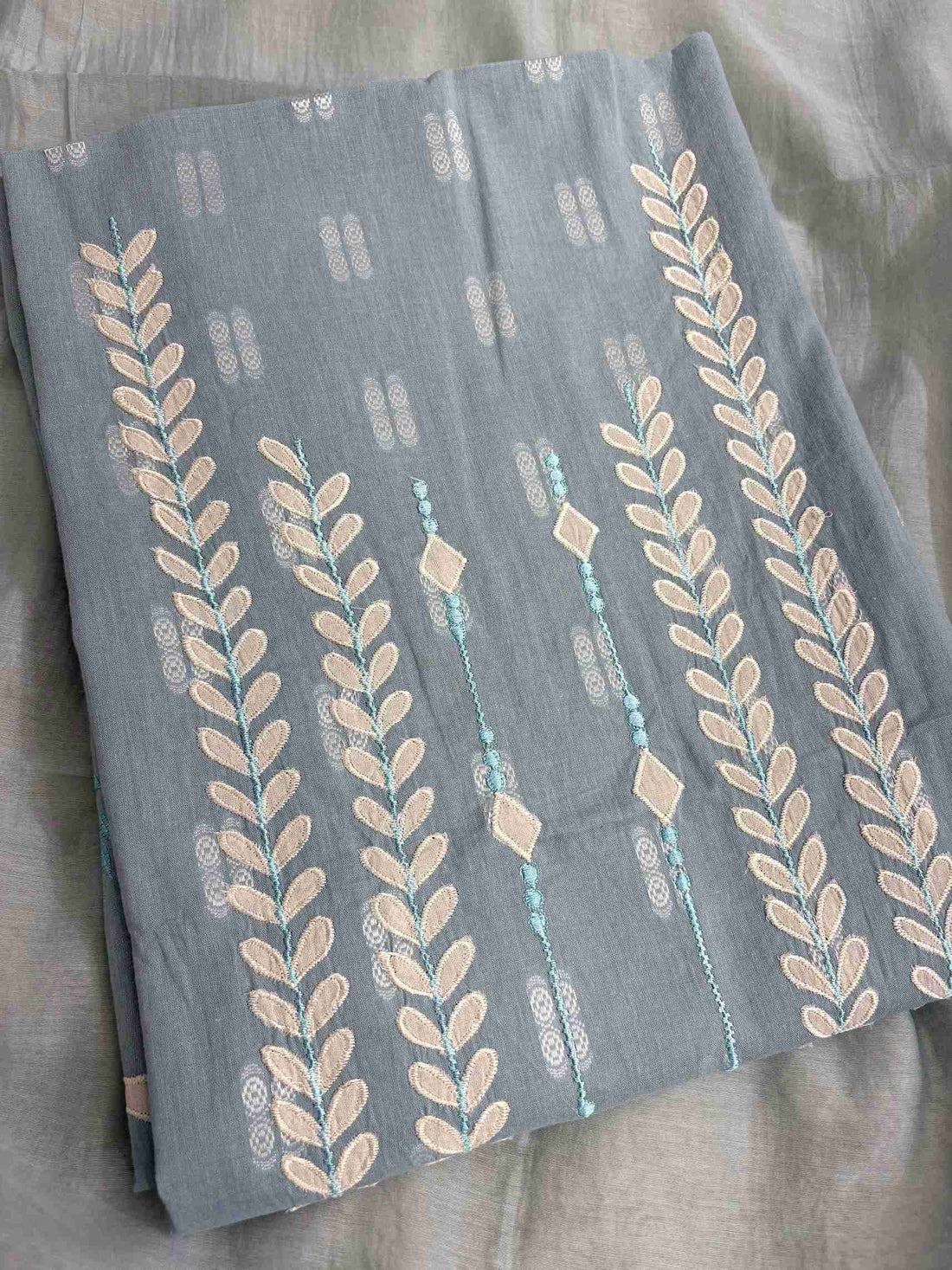 White applique botanical motif highlight at hemline of steel blue cotton shirt