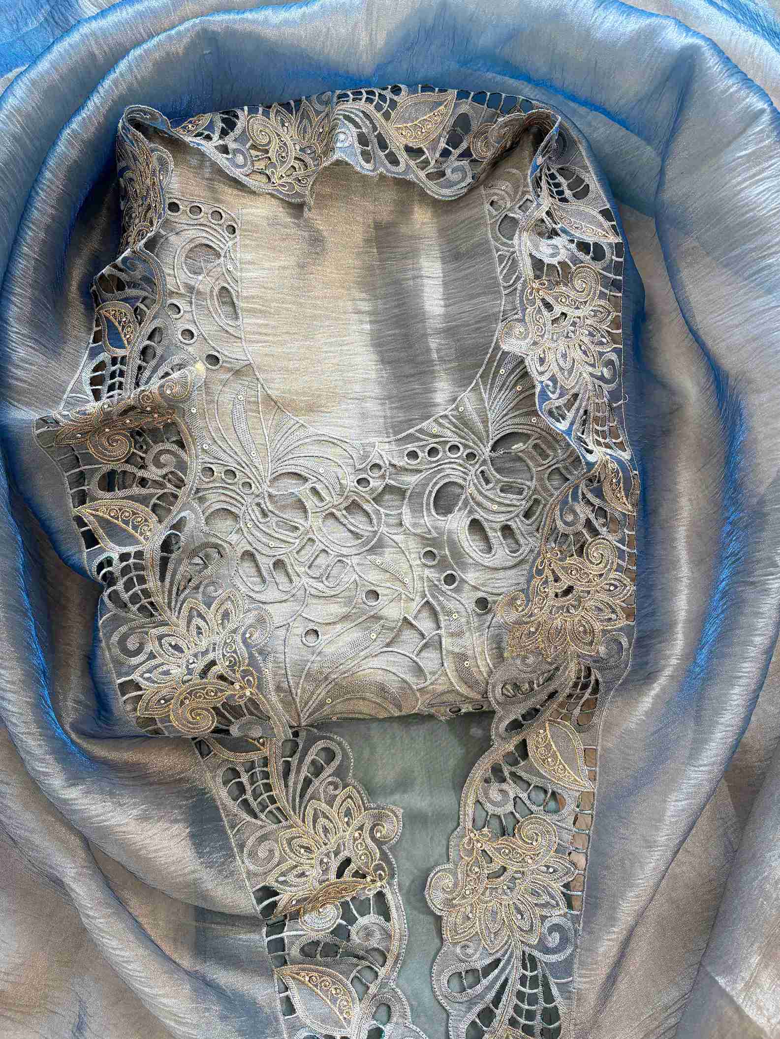 Close-up of cutwork panel at the neckline of steel blue shimmer tissue suit