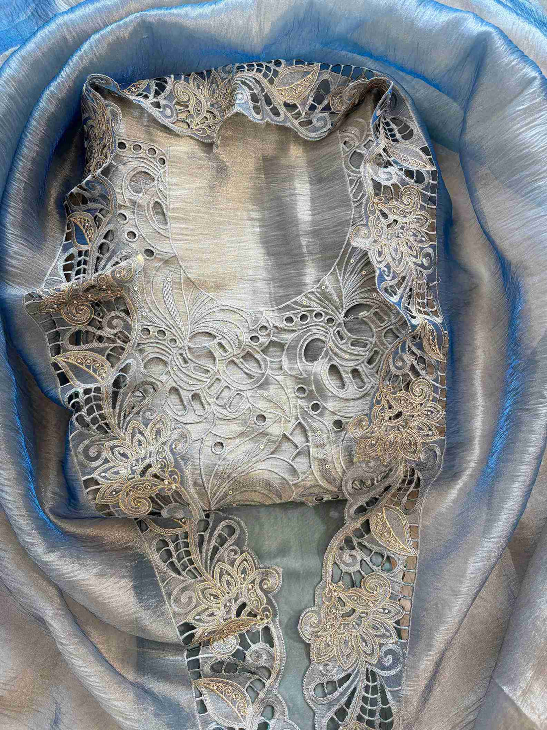 Close-up of cutwork panel at the neckline of steel blue shimmer tissue suit