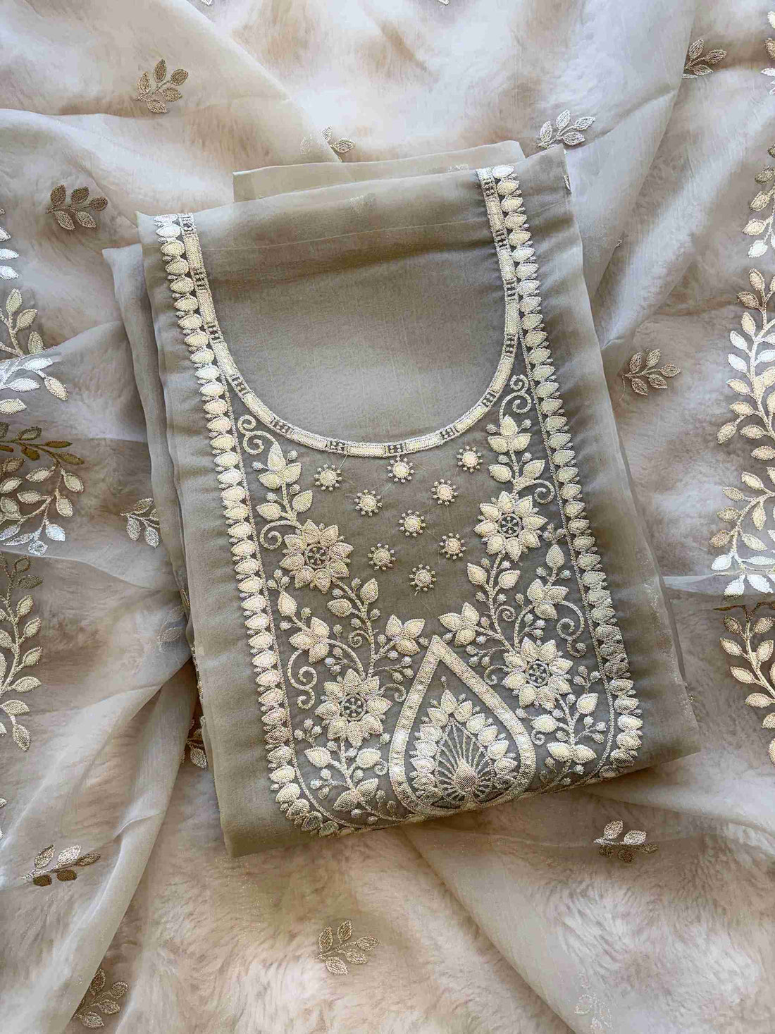 Close-up of leather gota work neckline on taupe beige shimmer tissue suit