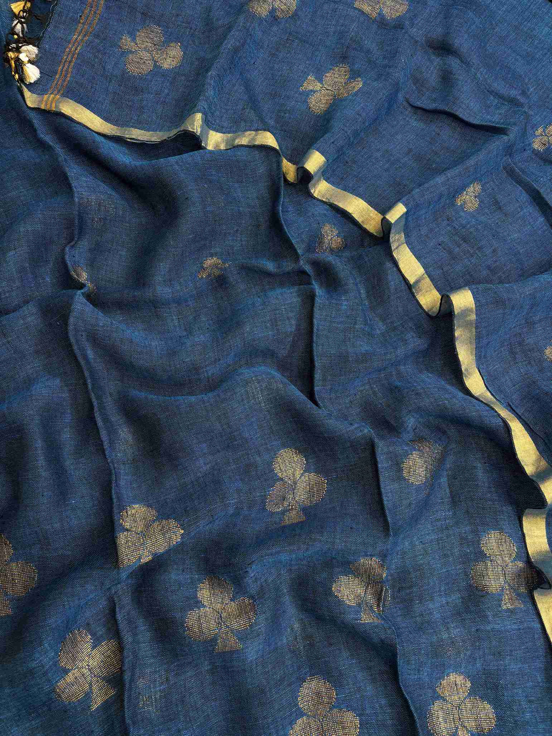Scattered golden geometric spade woven motifs across teal blue pure handloom linen dupatta surface