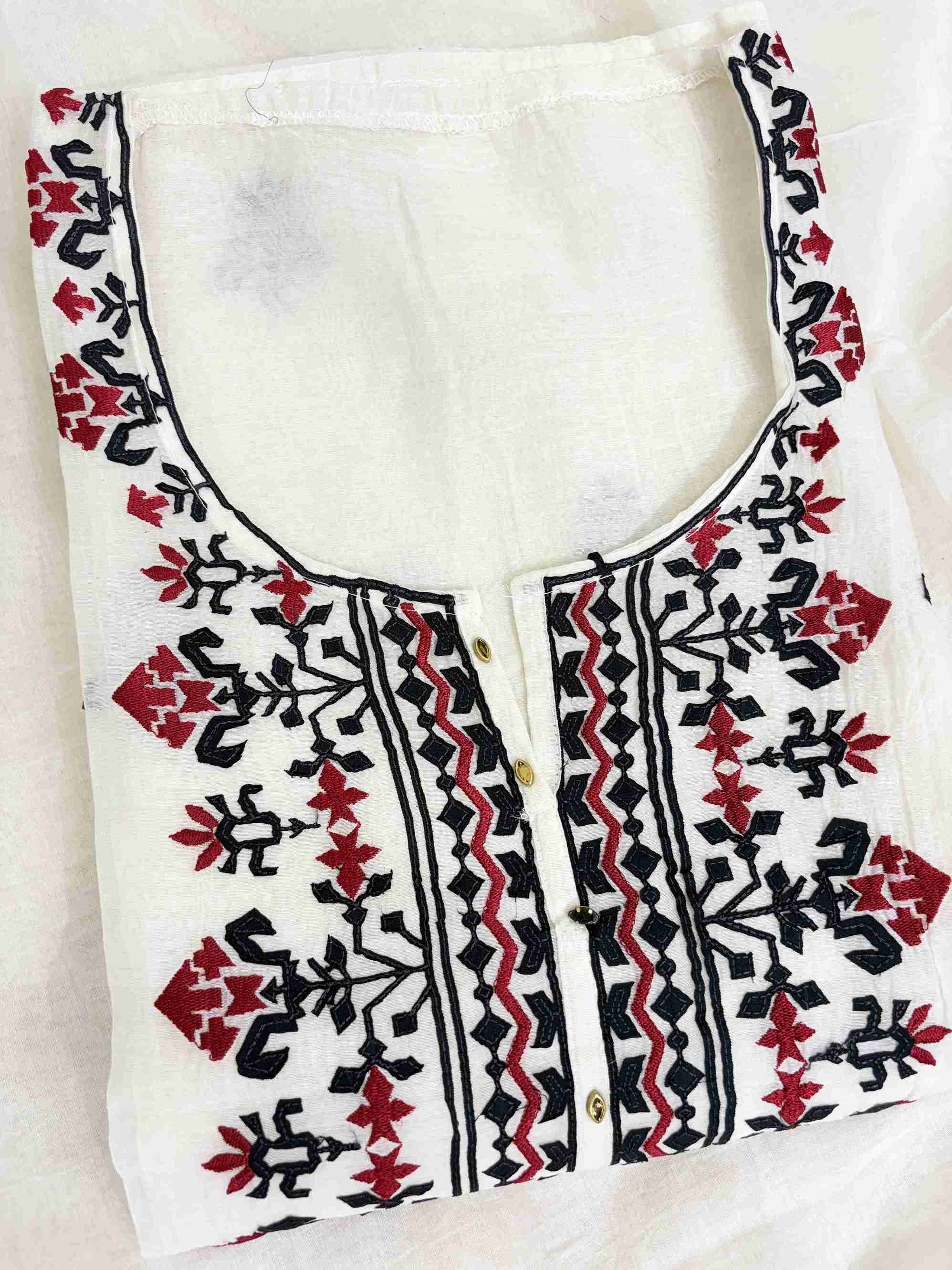 Scattered black applique and red thread geometric motifs across white mul chanderi shirt body