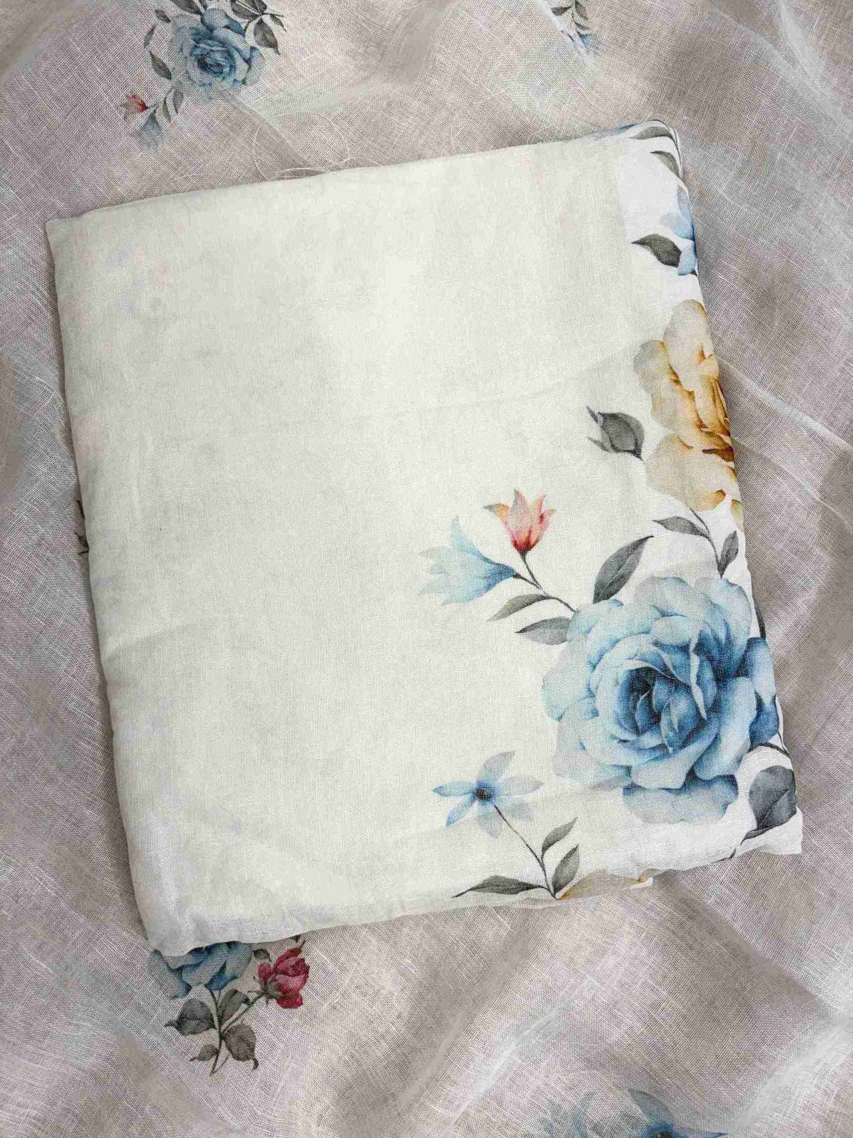 Close-up of digital blue roses, golden-amber roses, and pink accent flowers on white pure linen shirt hemline