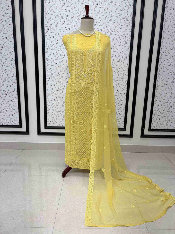 Scattered chikankari floral motifs across the surface of yellow chiffon dupatta