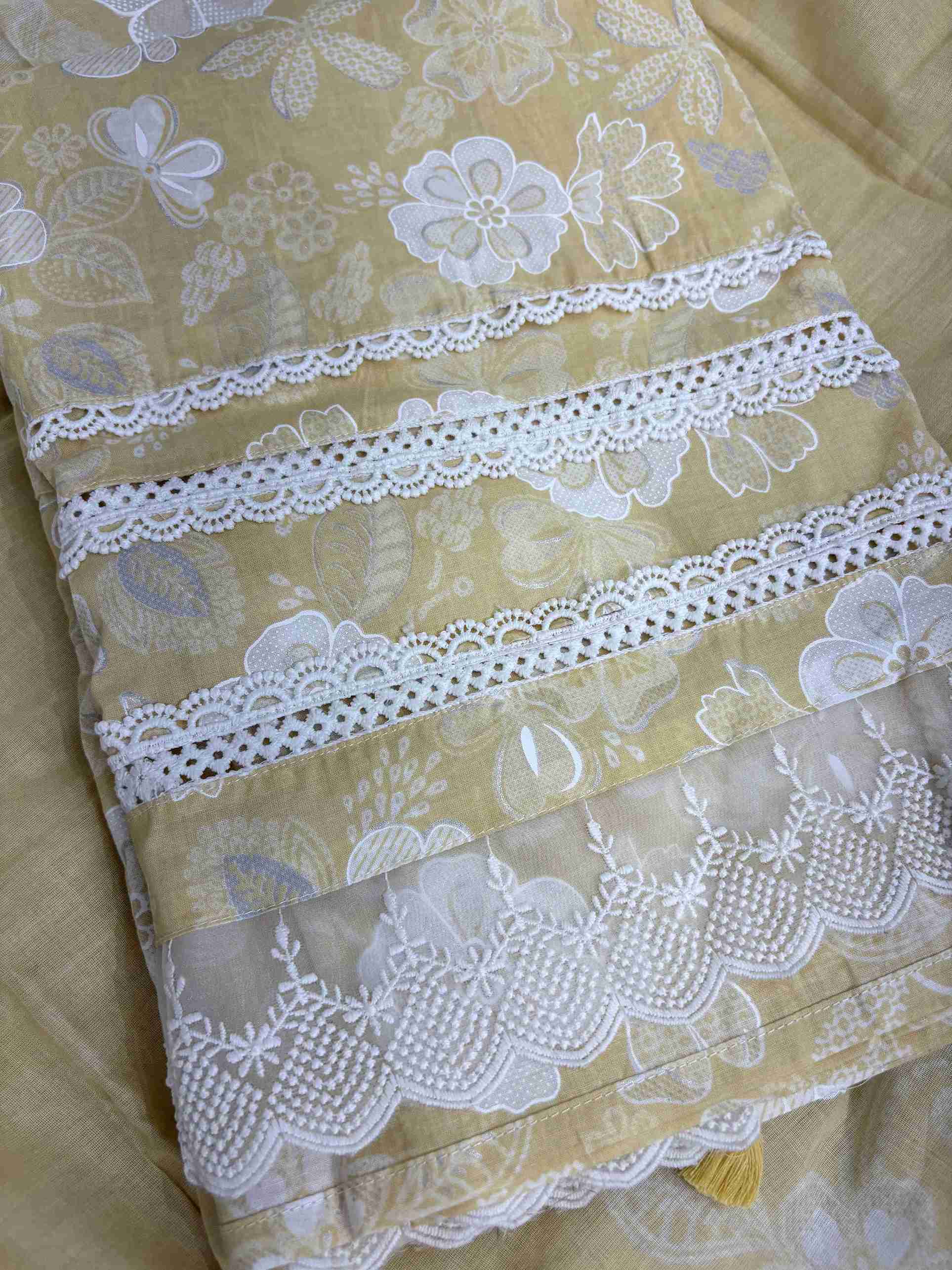 Multiple row crotia lace hemline finishing detail at the bottom of yellow cotton shirt