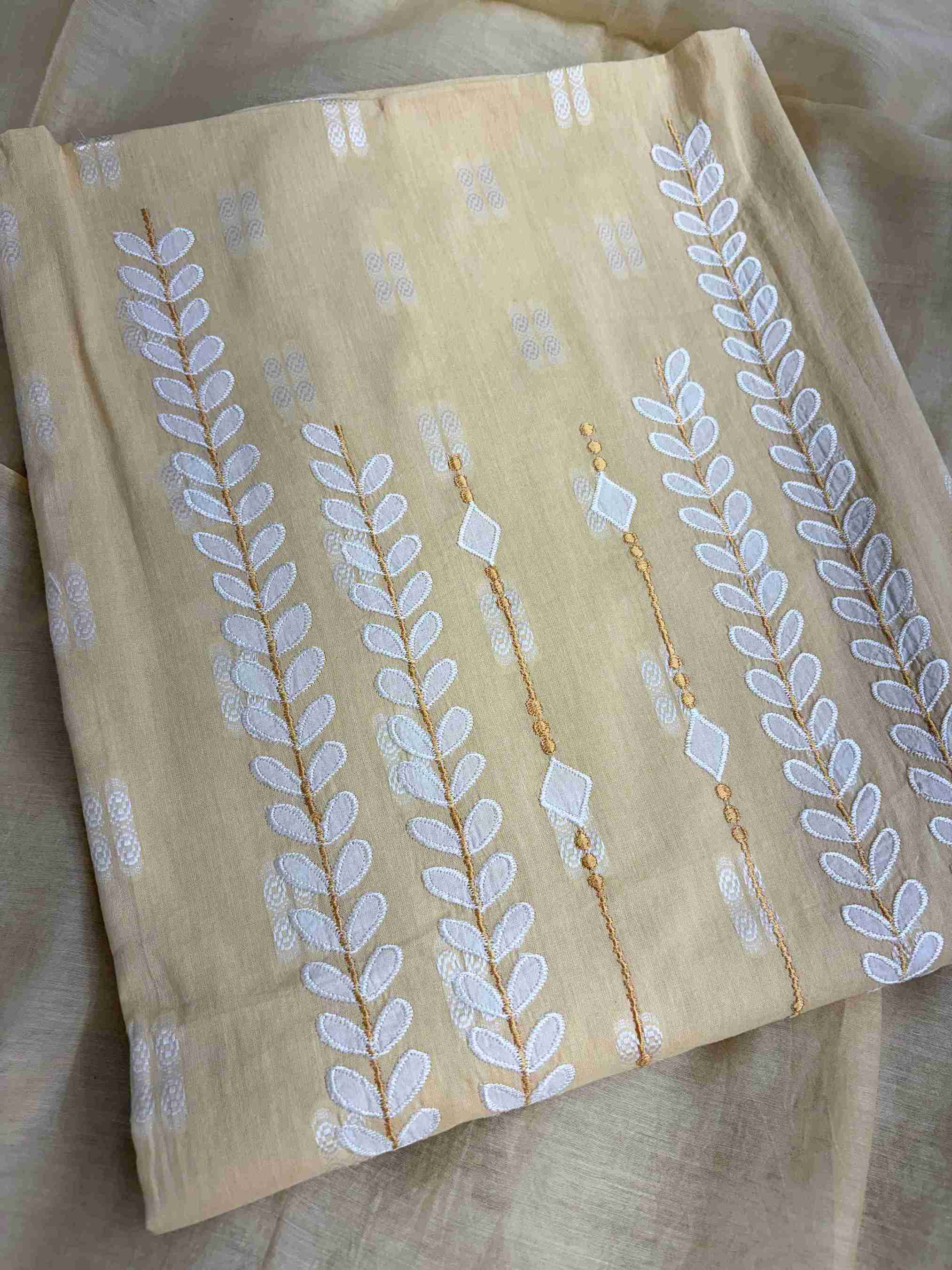 White applique botanical motif highlight at hemline of yellow cotton shirt