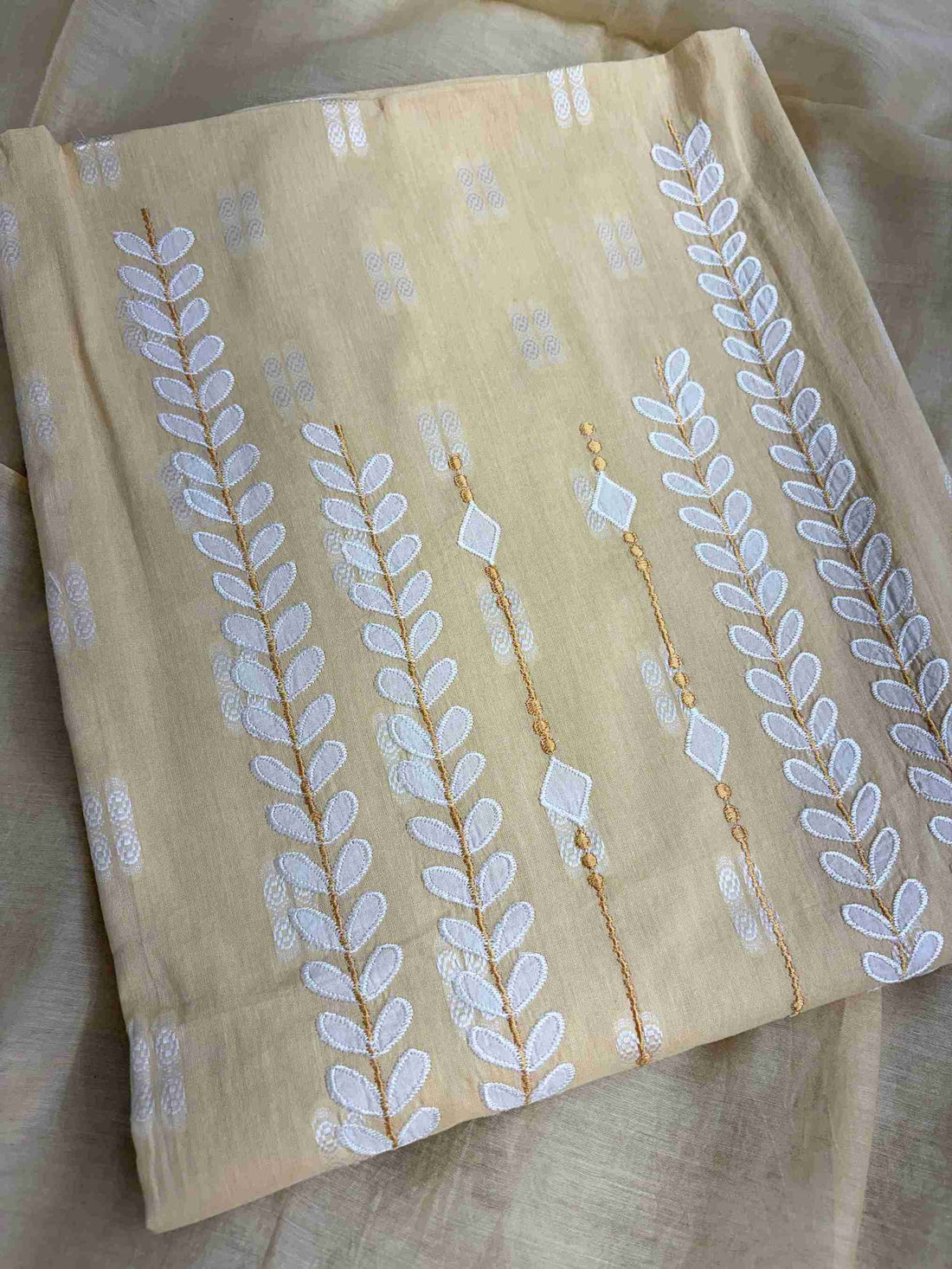 White applique botanical motif highlight at hemline of yellow cotton shirt