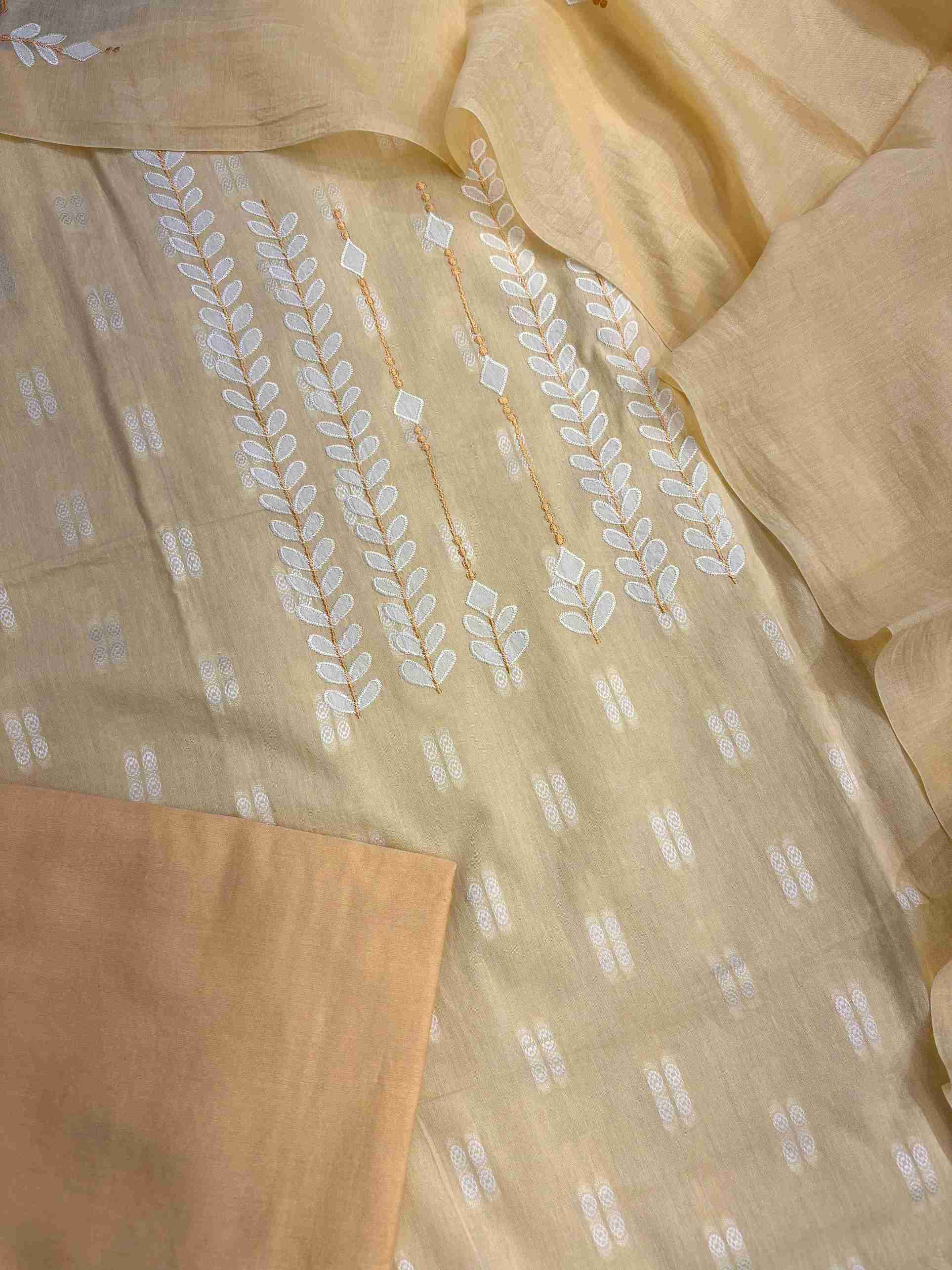 Complete yellow cotton unstitched suit flat lay set with shirt, mul cotton dupatta, and cotton bottom