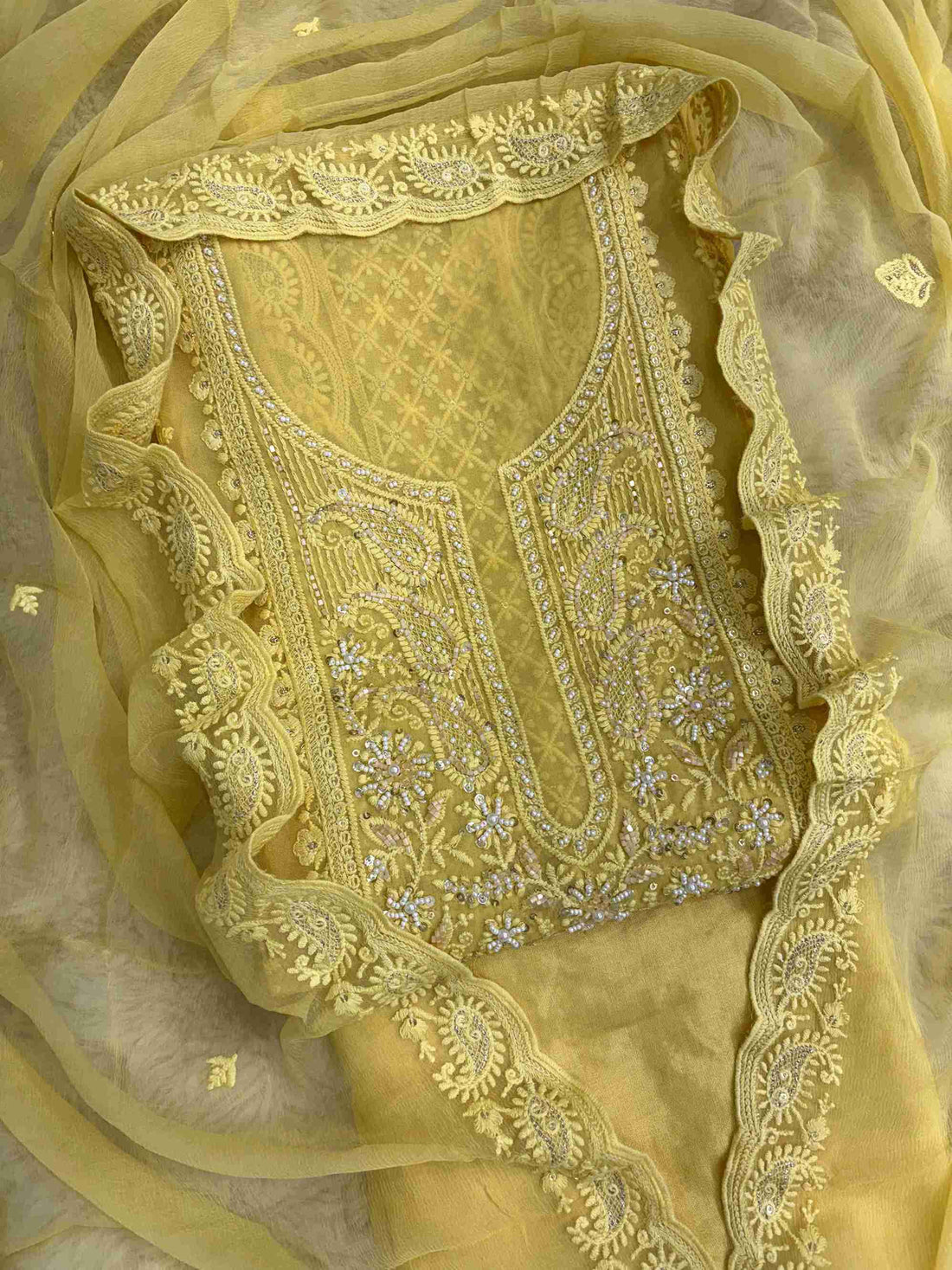 Close-up of chikankari neckline panel with moti, bead, and sequin embellishment on yellow georgette shirt